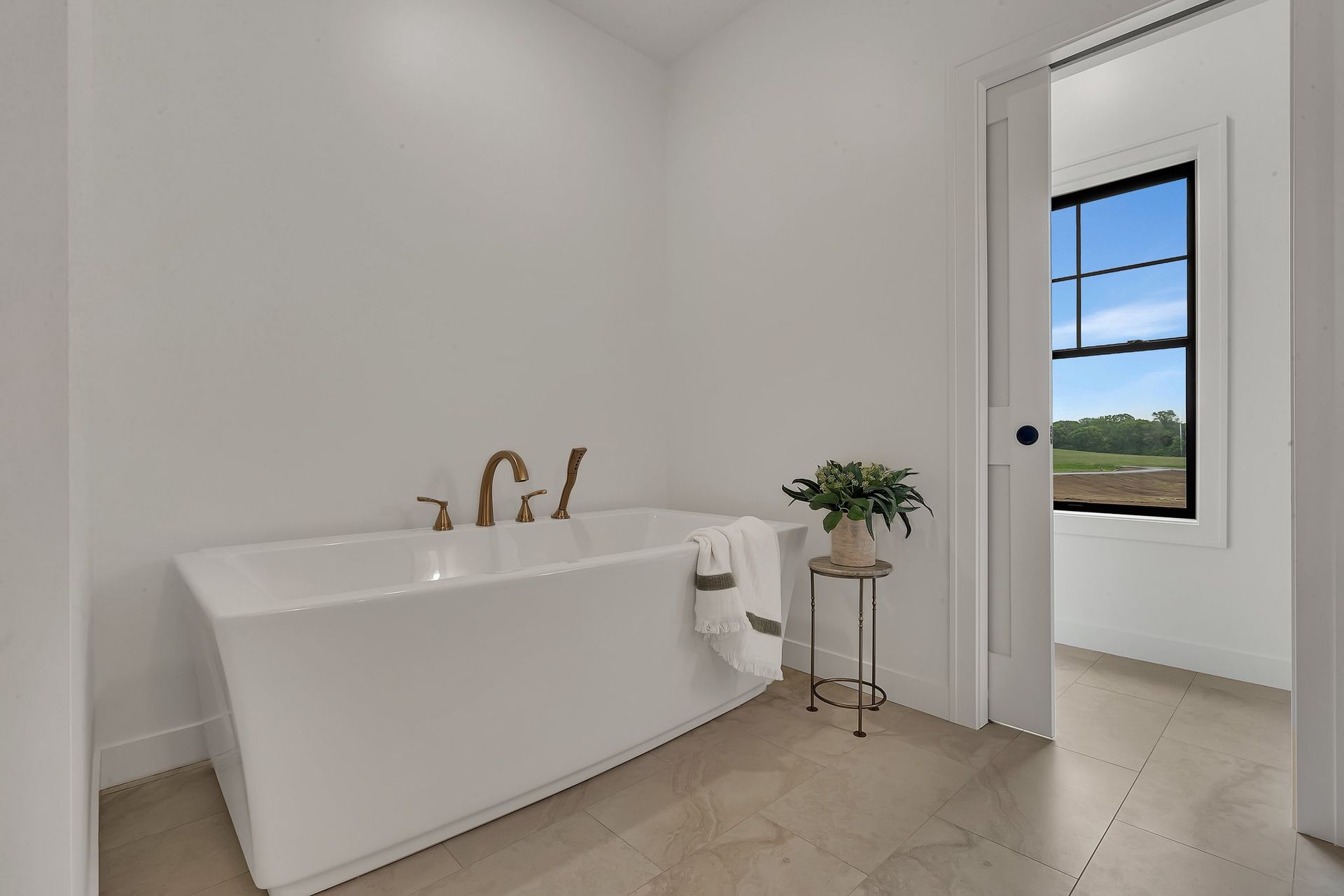 A bathroom with a bathtub and a window.
