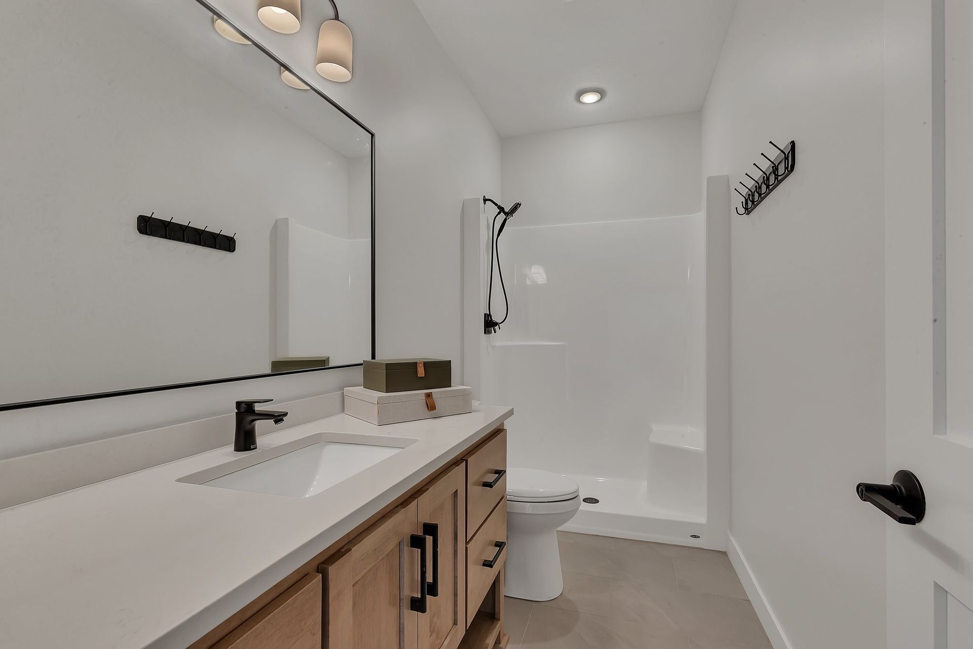 A bathroom with a sink , toilet , shower and mirror.