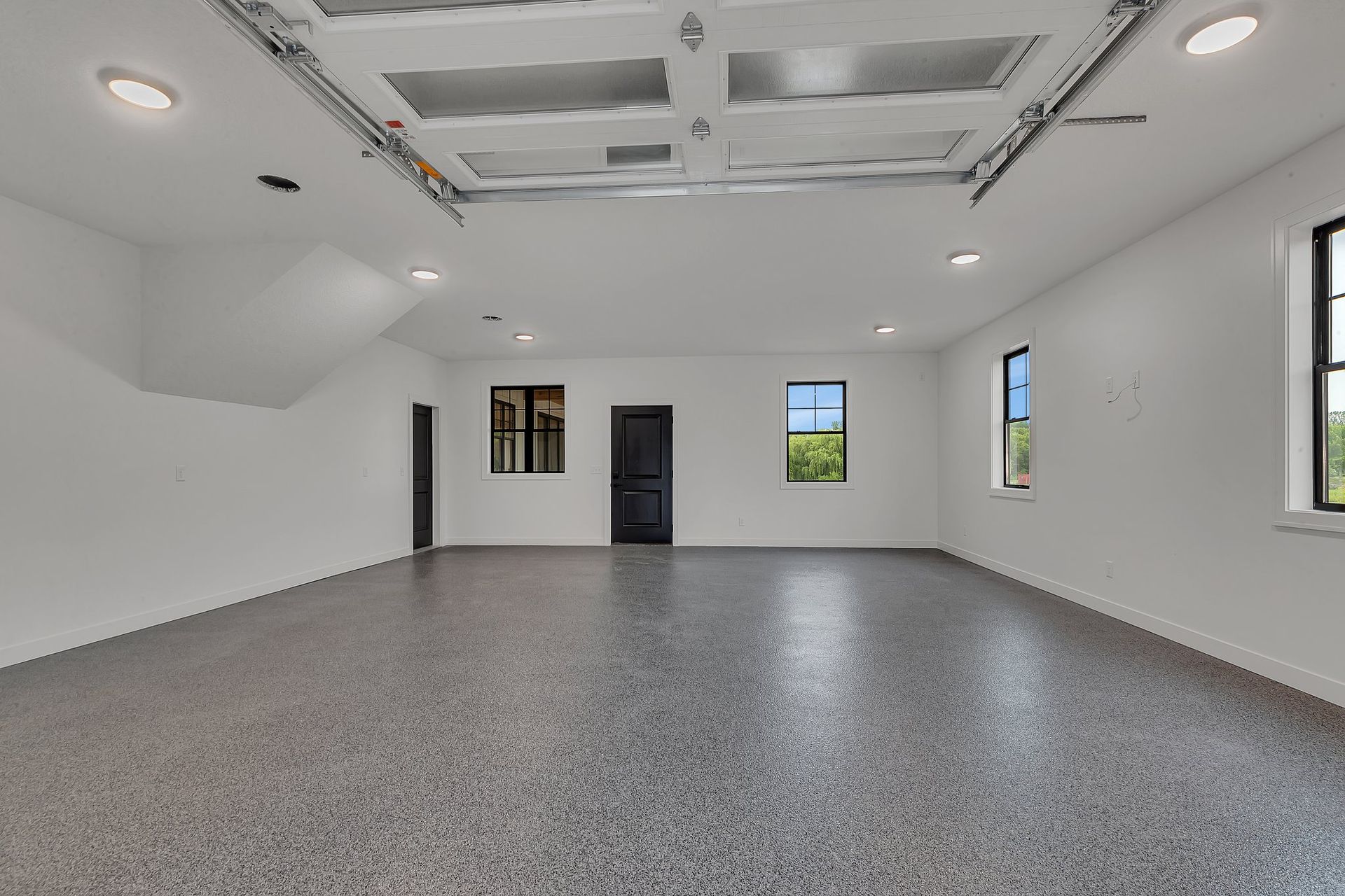 An empty garage with a gray floor and white walls.