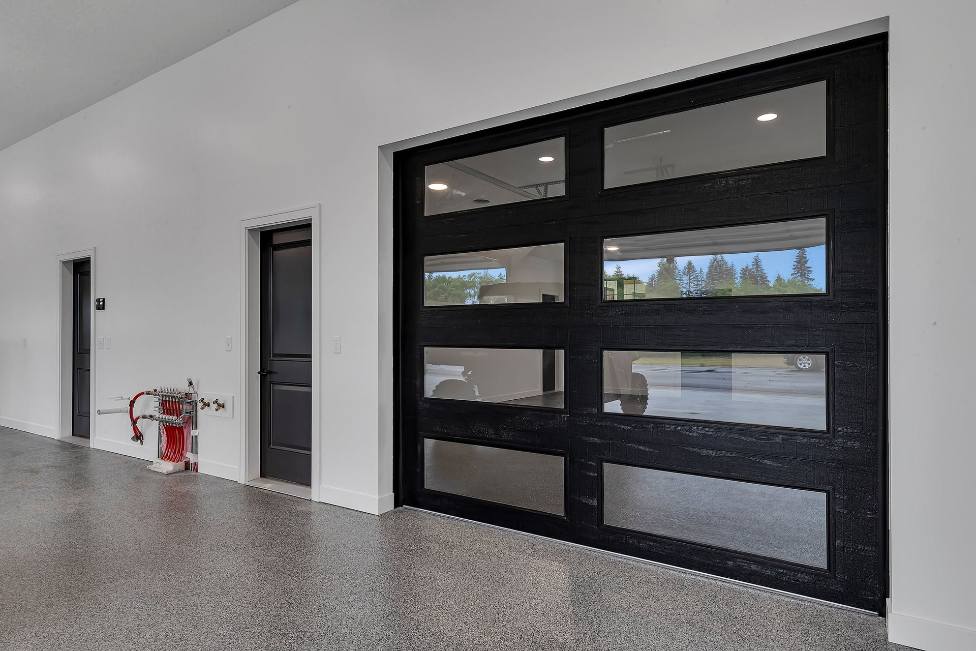 A garage with a black garage door and a fire extinguisher.