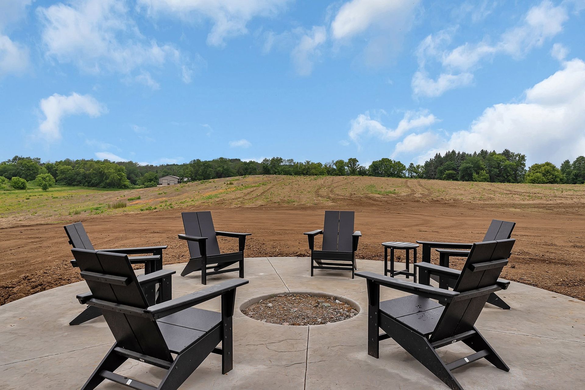 A group of chairs are sitting around a fire pit.