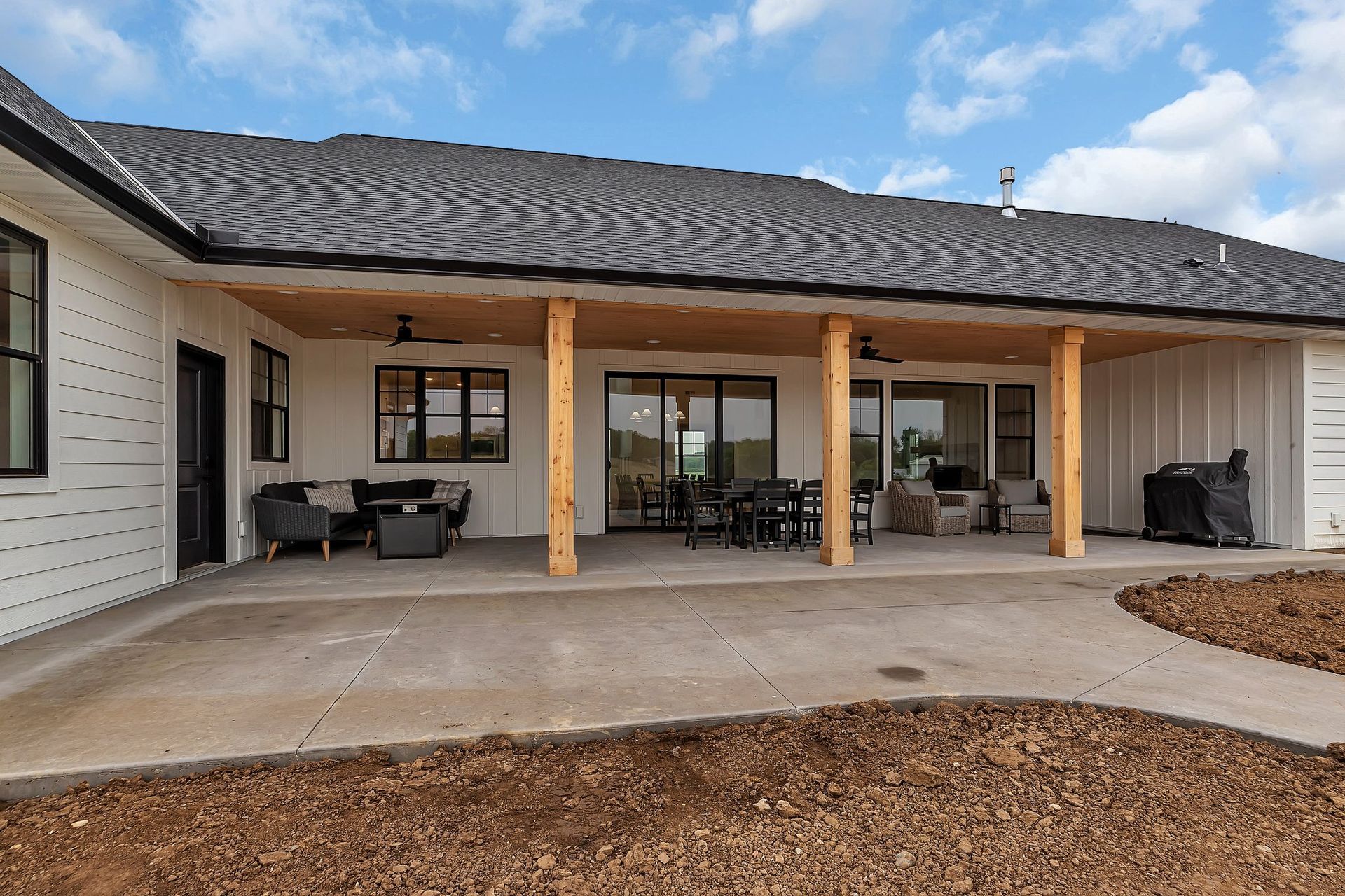 The backyard of a house with a large covered patio.