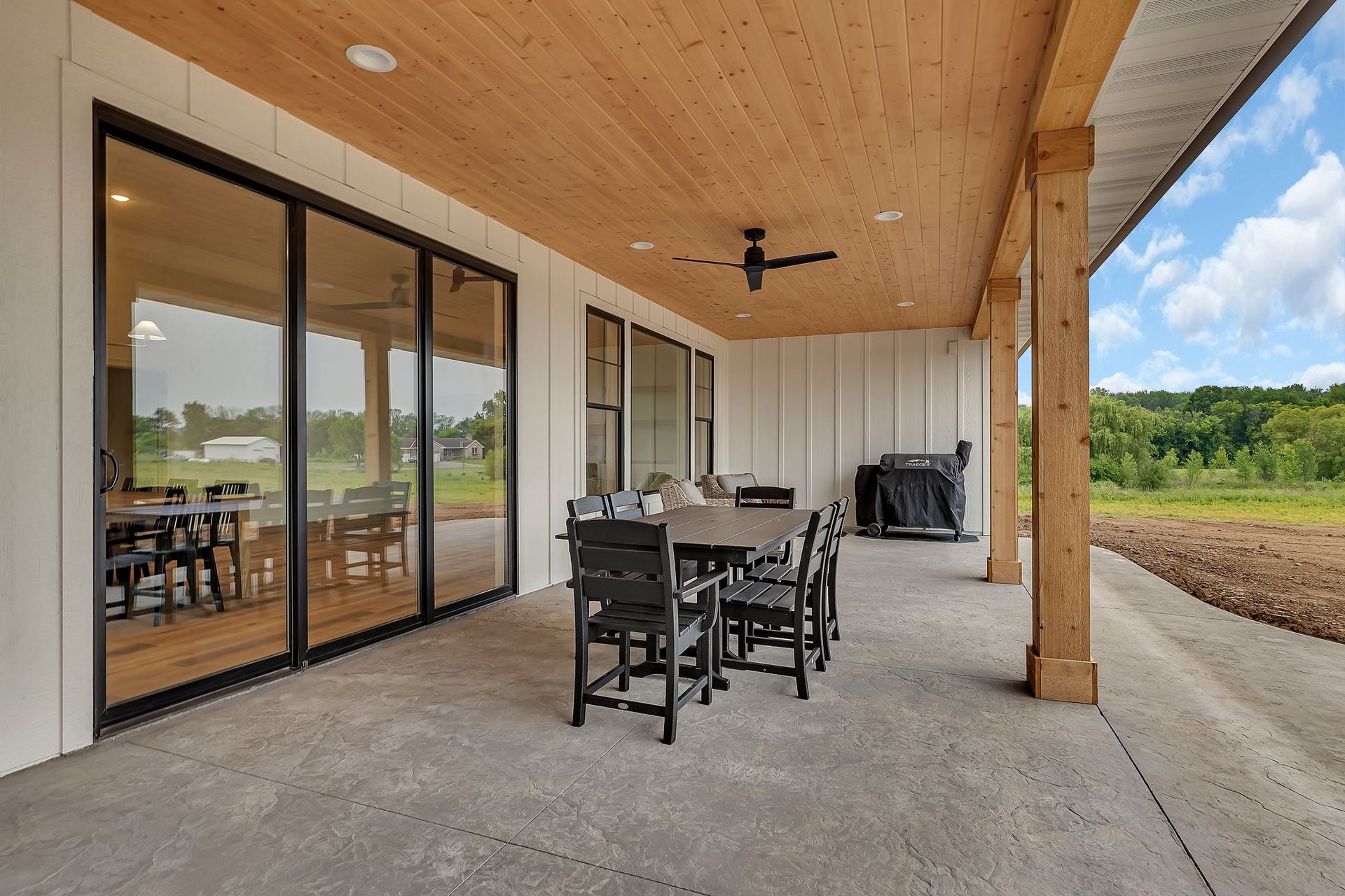 A large patio with a table and chairs and a ceiling fan.