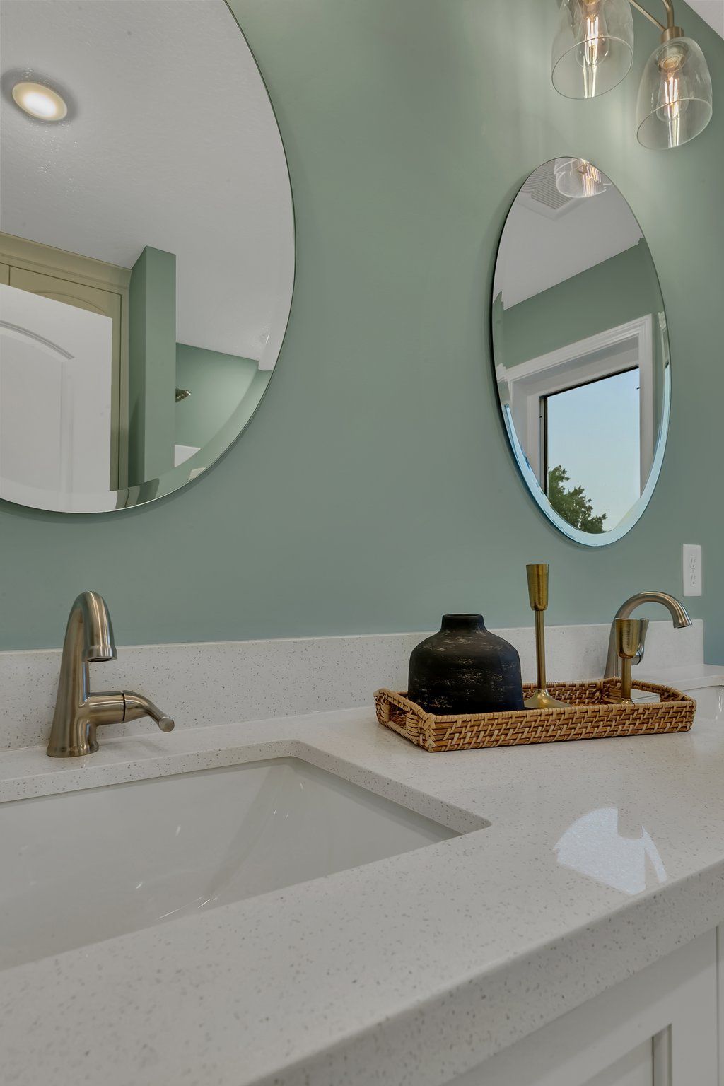 A bathroom with two sinks and two mirrors on the wall.