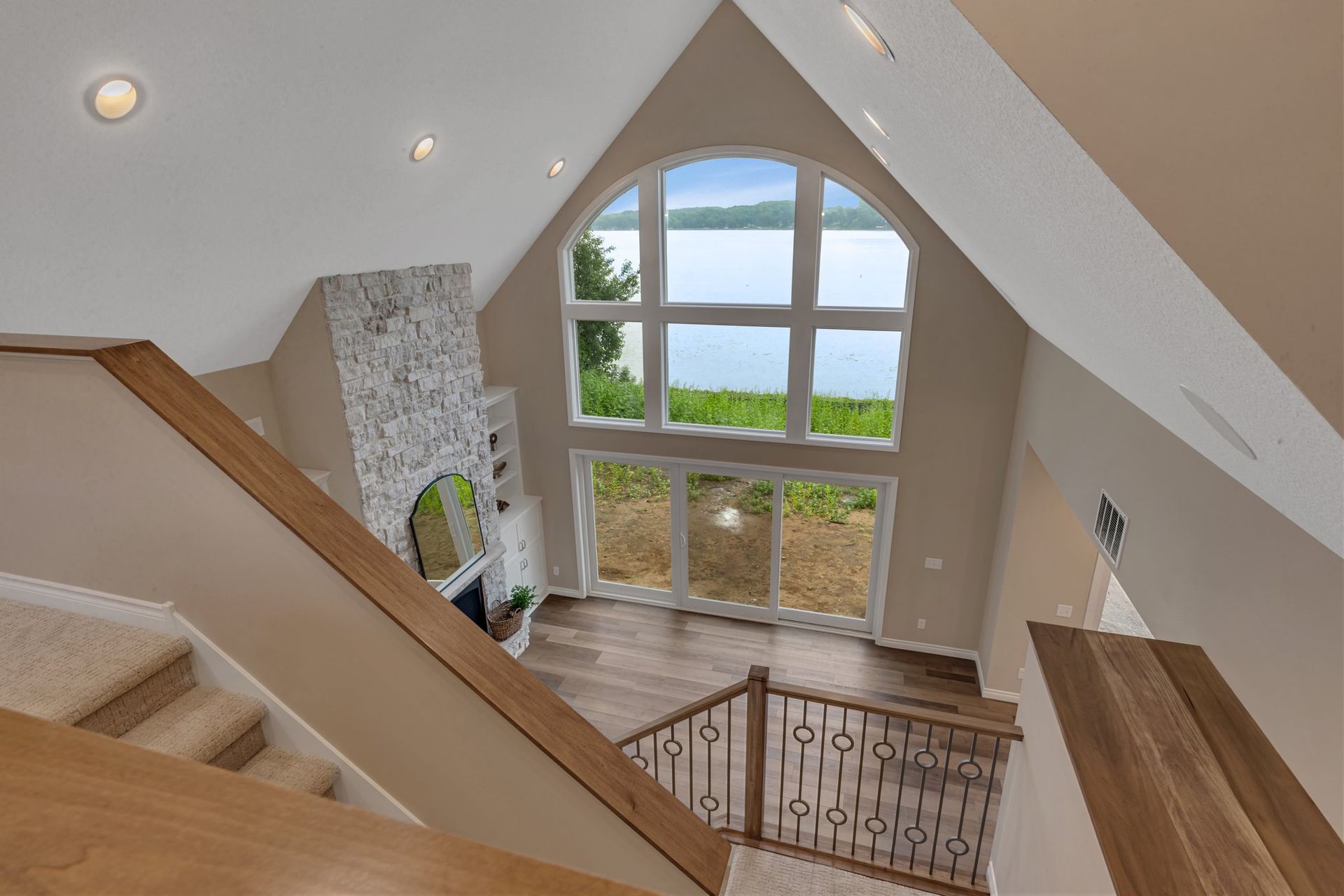 A view of a lake from the second floor of a house.