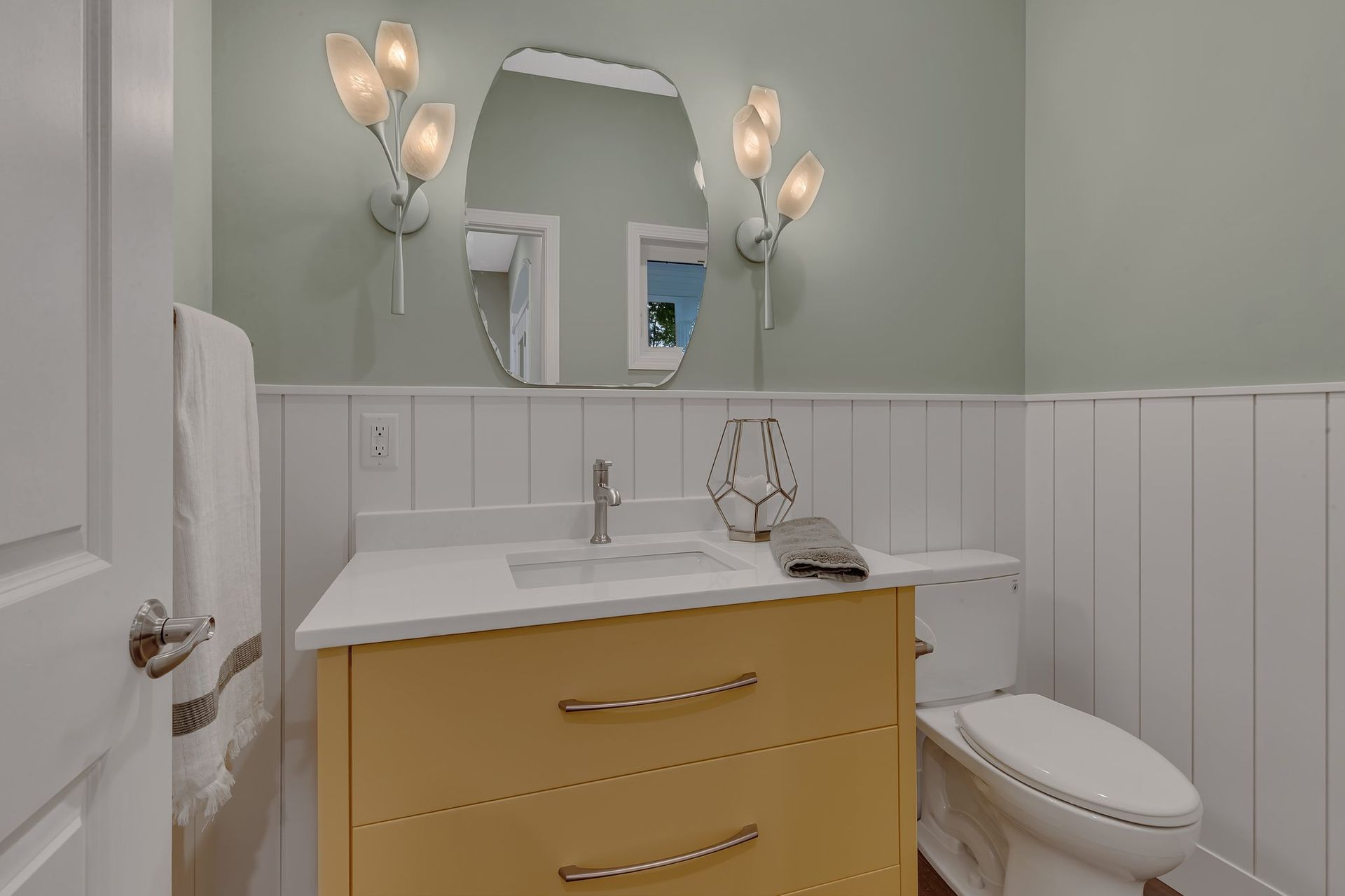 A bathroom with a sink , toilet and mirror.