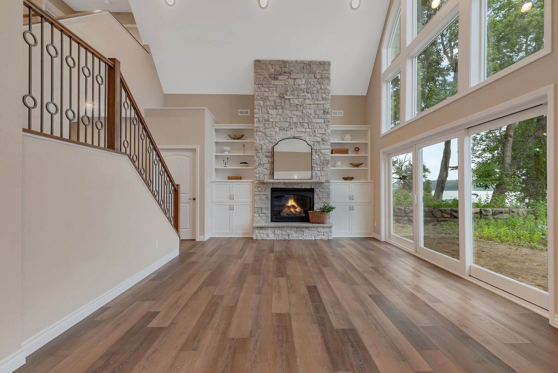 A living room with hardwood floors , a fireplace and stairs.