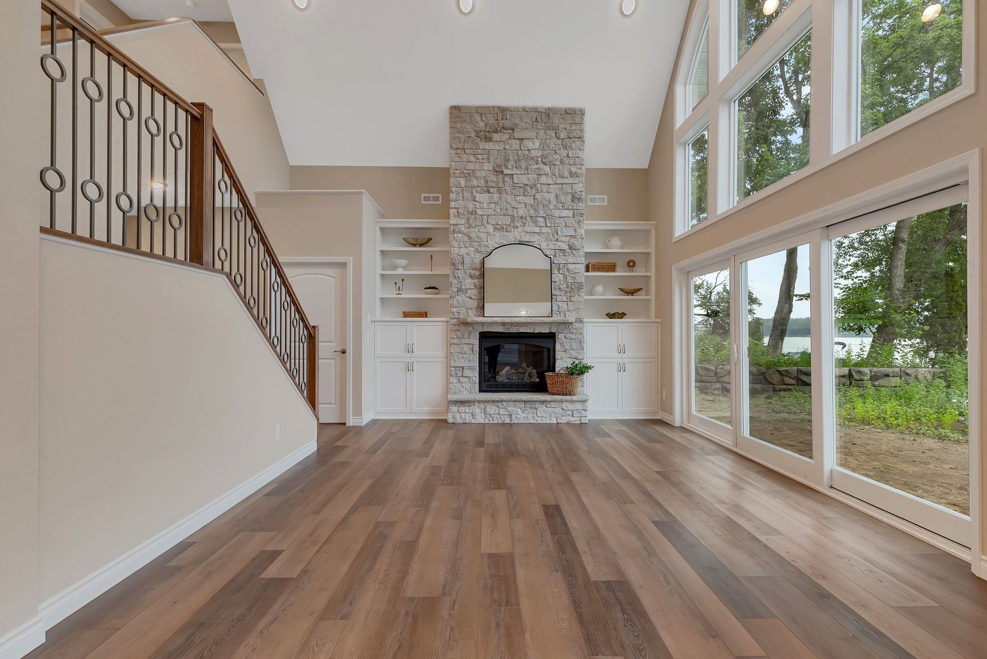 A living room with hardwood floors , a fireplace and stairs.
