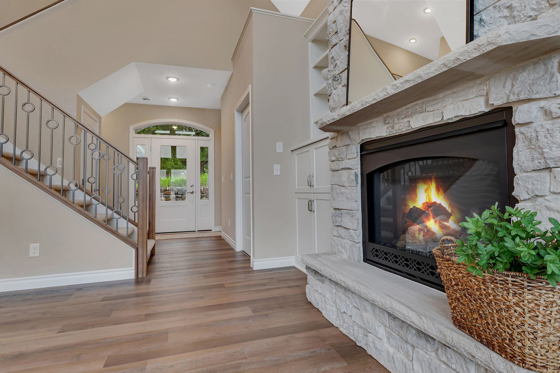 A living room with a fireplace and stairs in the background.