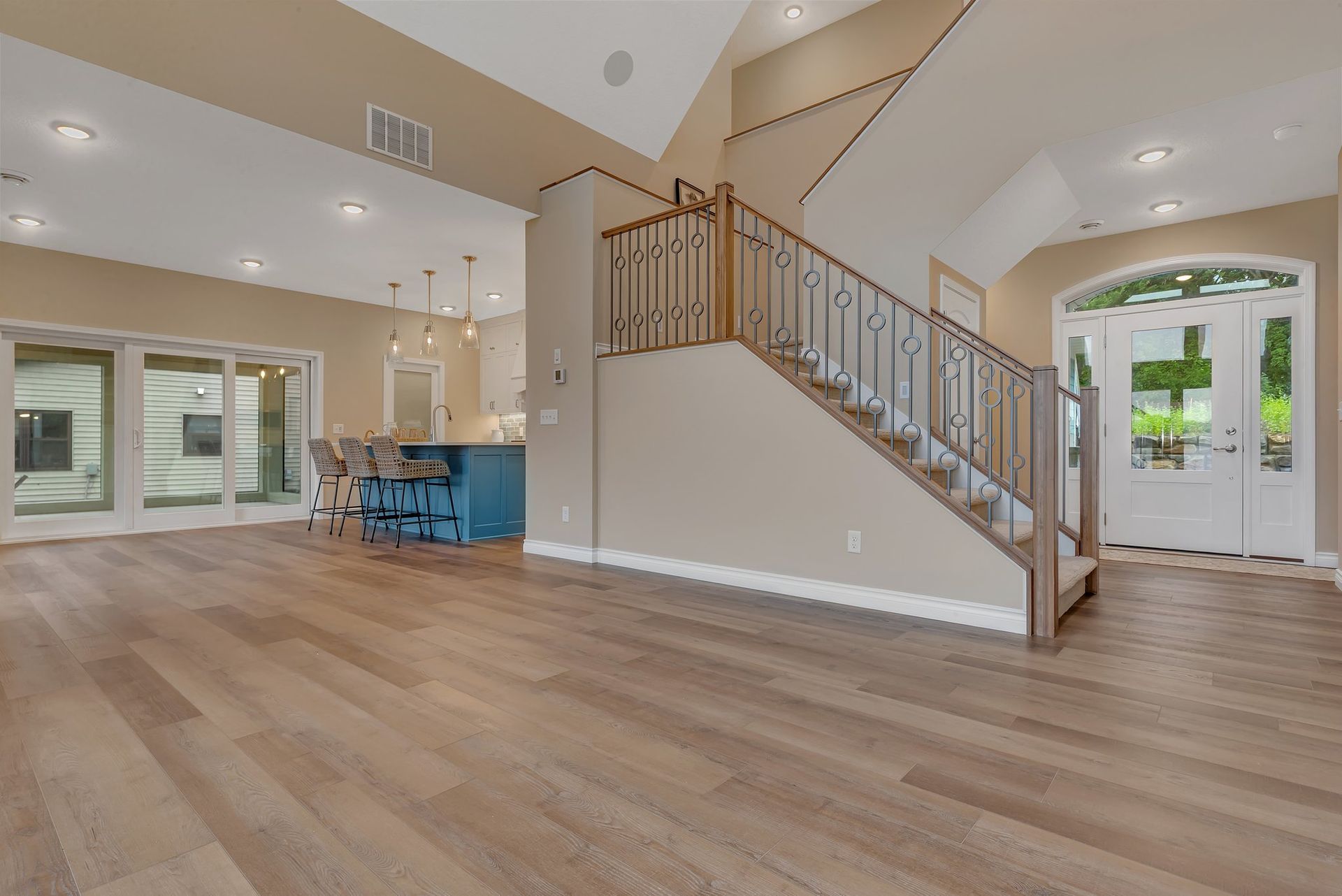 A living room with hardwood floors and stairs leading up to the second floor.