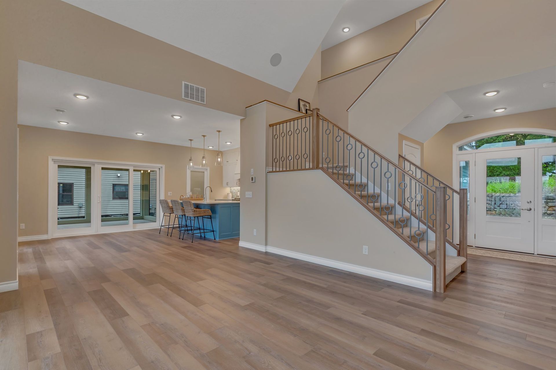 A living room with hardwood floors and stairs leading up to the second floor.