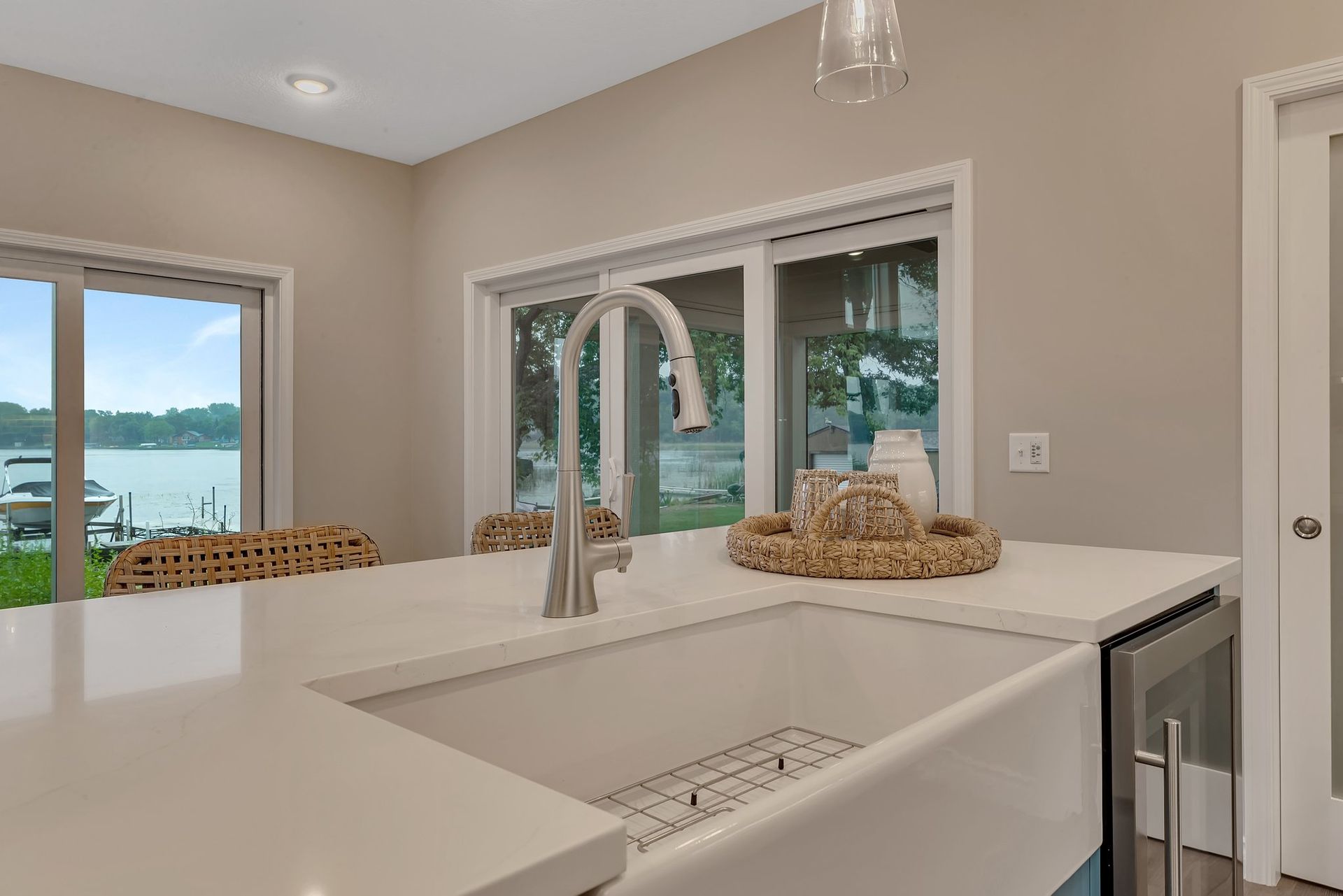 A kitchen with a sink and a window with a view of the water.