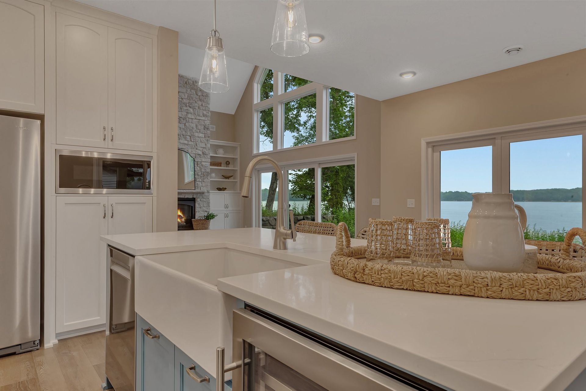 A kitchen with a sink and a refrigerator and a view of the water.