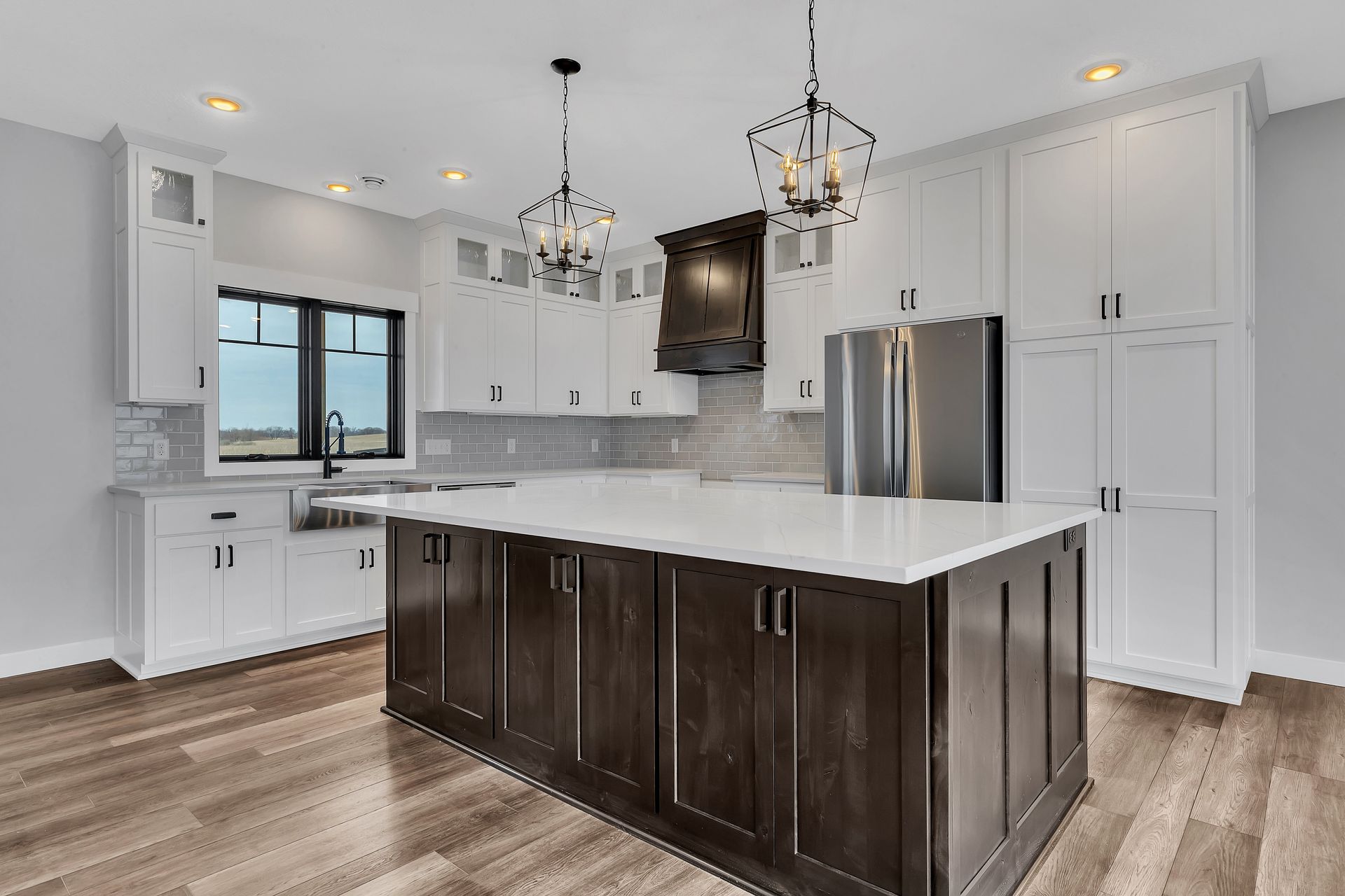 A kitchen with white cabinets and a large island in the middle.
