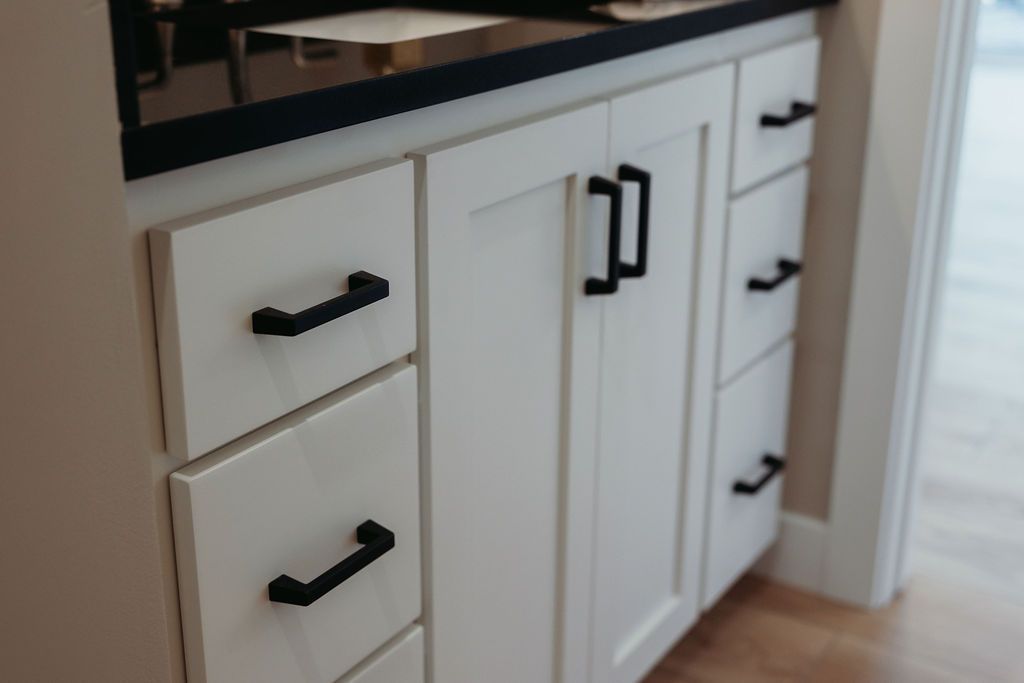 White bathroom vanity with black hardware.