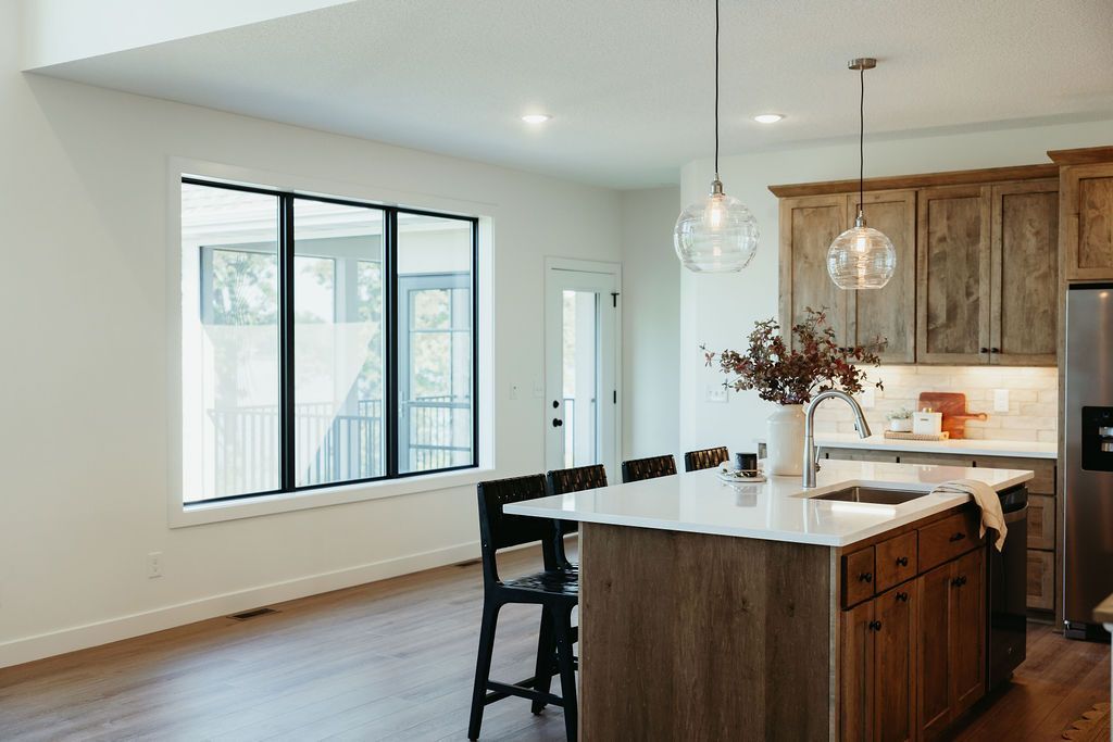 Modern kitchen with wood cabinets, island, and large window.