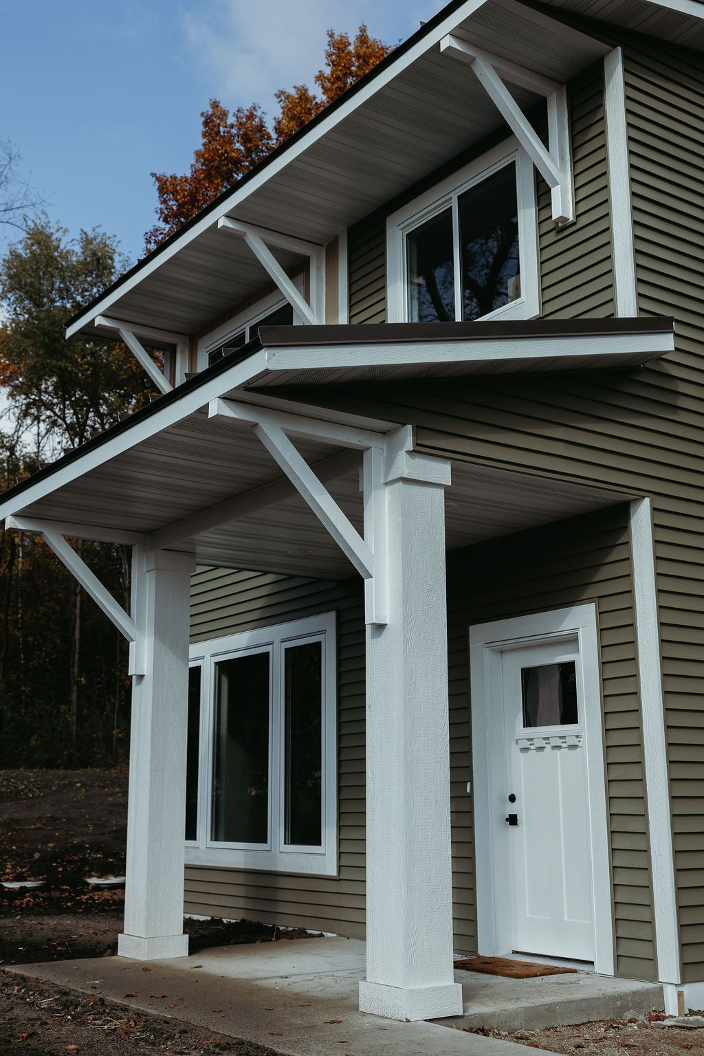 Two-story house with green siding, white trim, and a covered porch.