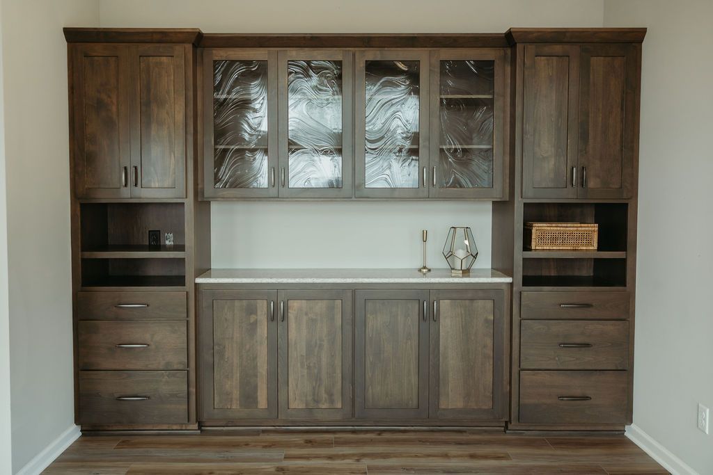 Dark wood built-in cabinet with glass-fronted upper cabinets, lower solid cabinets, and open shelving.