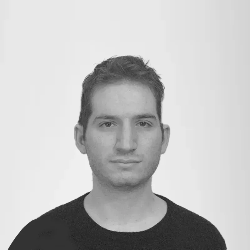 A black and white photo of a man wearing a black sweater.