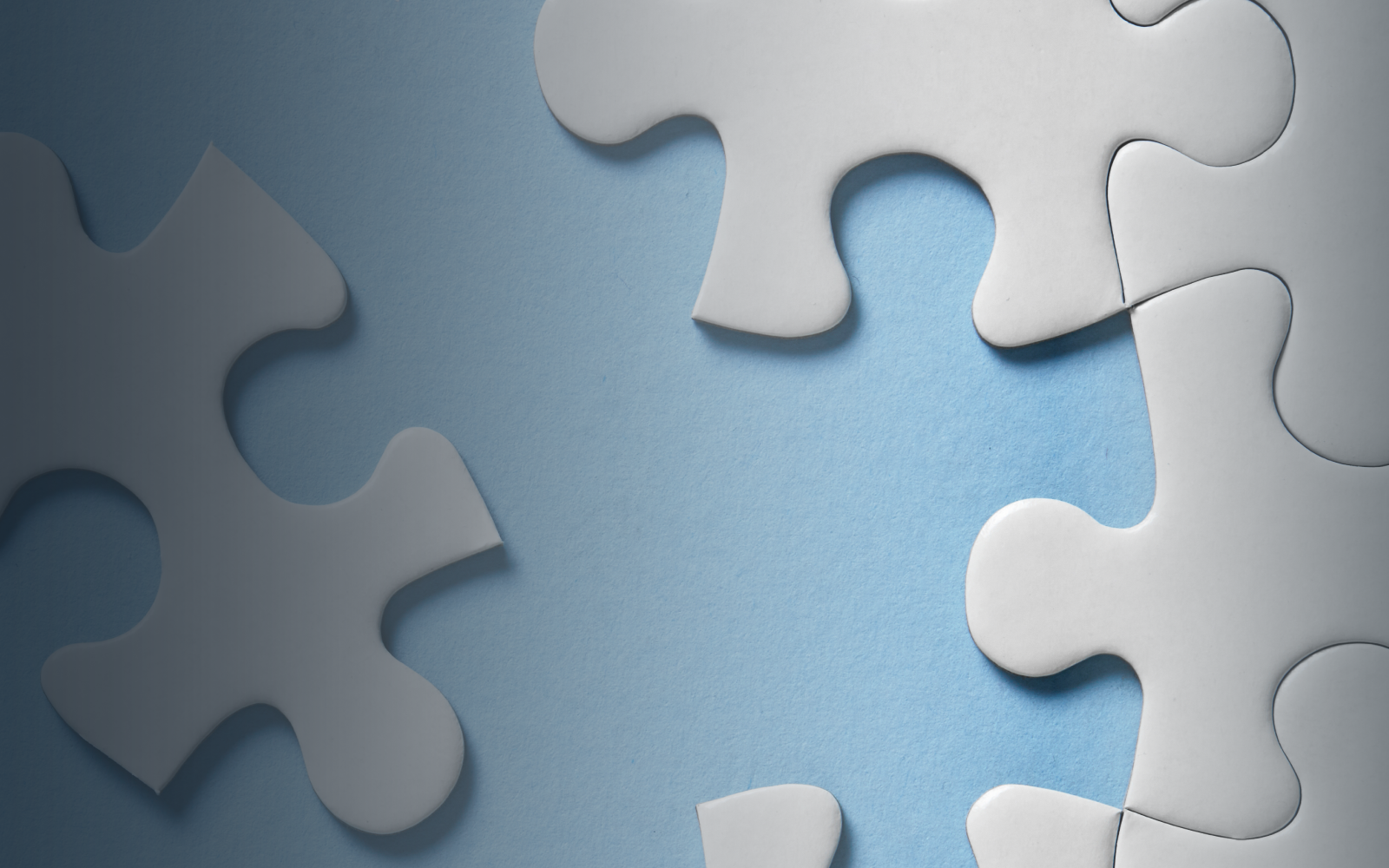 A partially assembled light blue puzzle with a missing piece in the center.