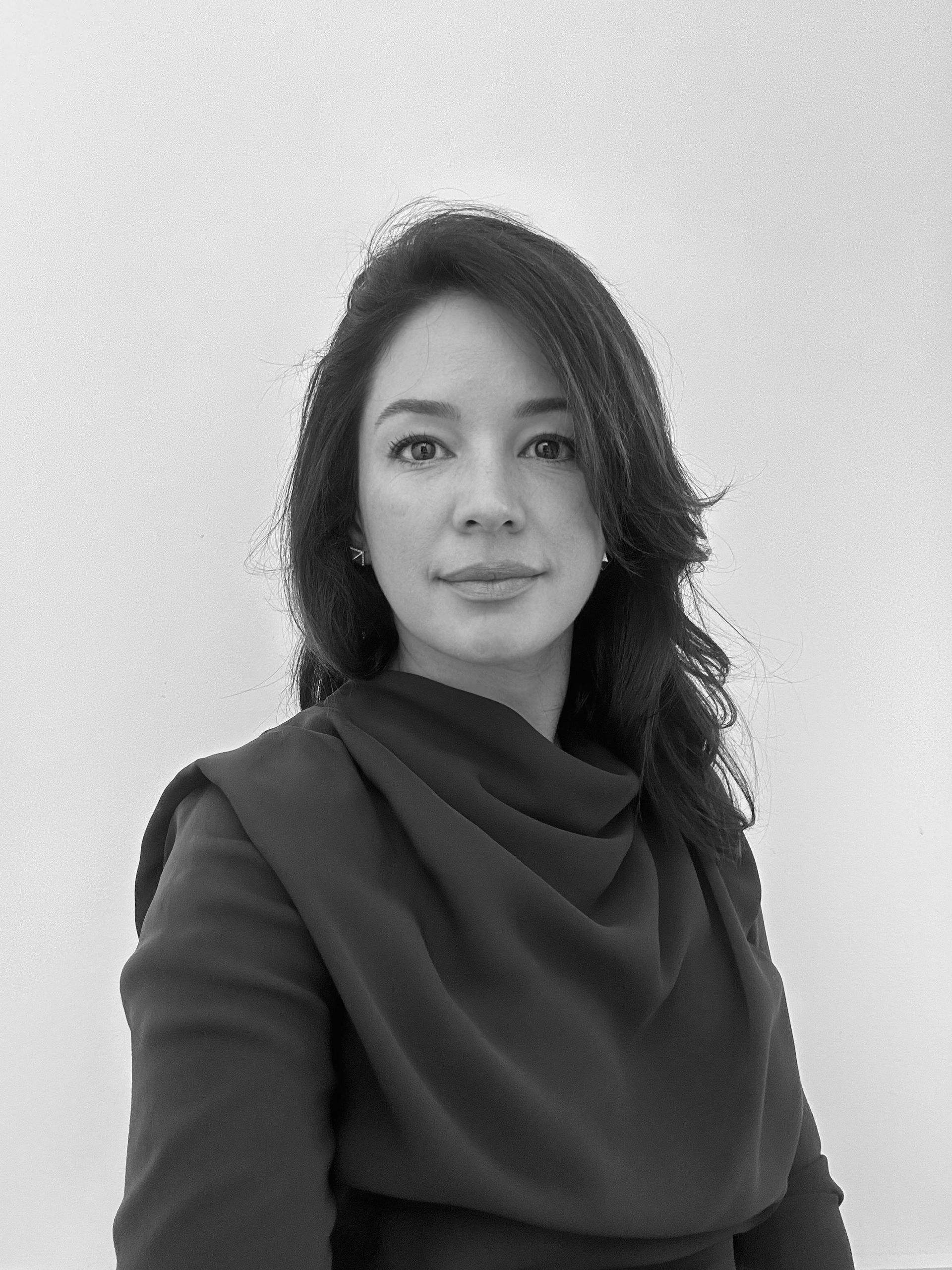 A black and white photo of a woman in a black dress.