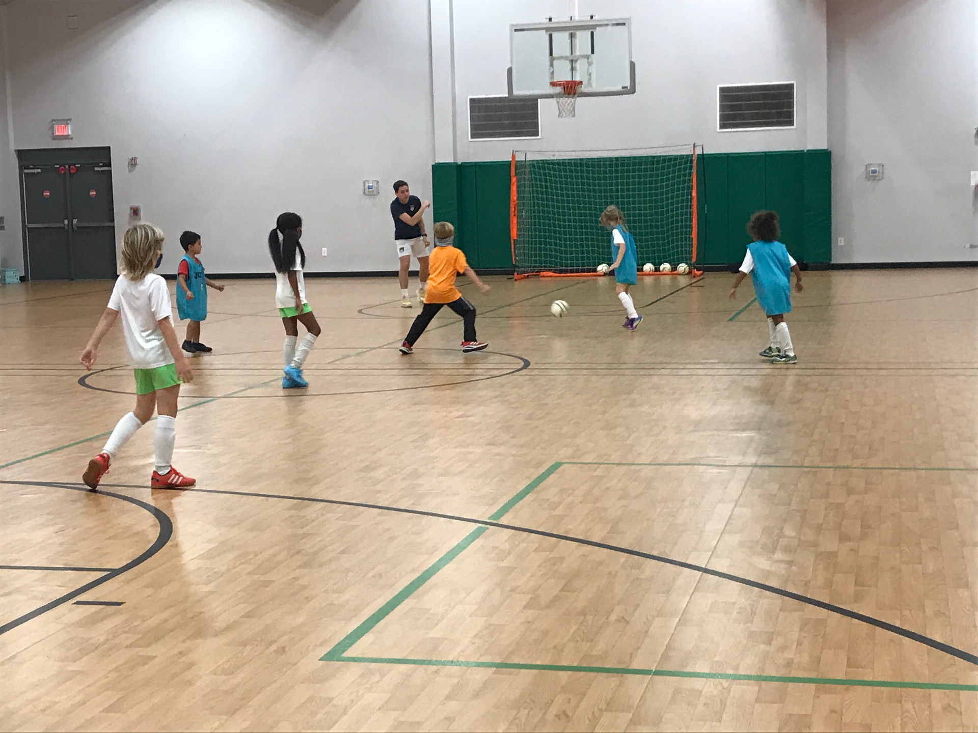a group of children are playing futsal in a camp