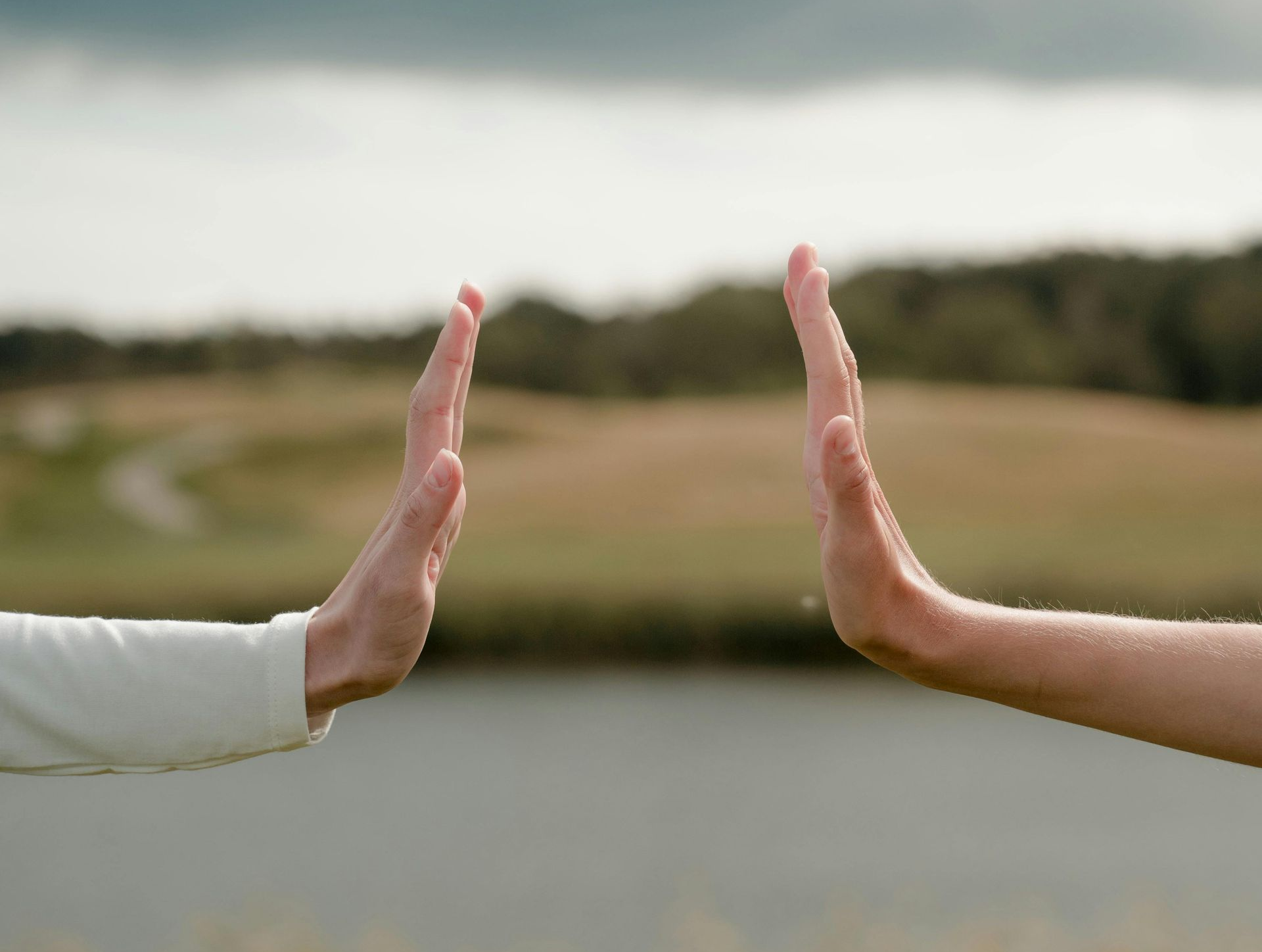 Twee handen met handpalmen naar elkaar, bijna rakend, symbool voor verbinding ontstaan in de tussenr