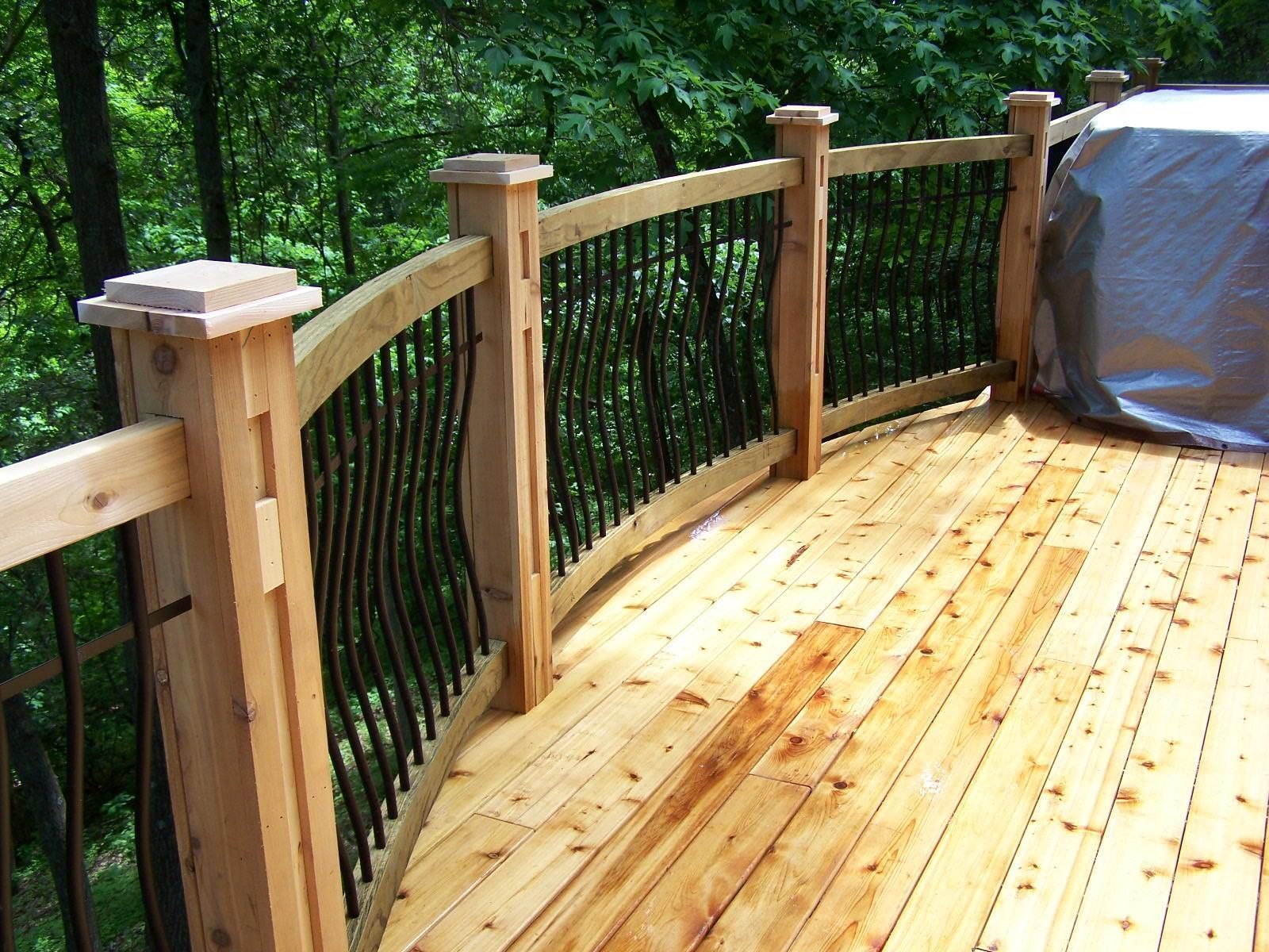 A curved wooden deck with a black railing
