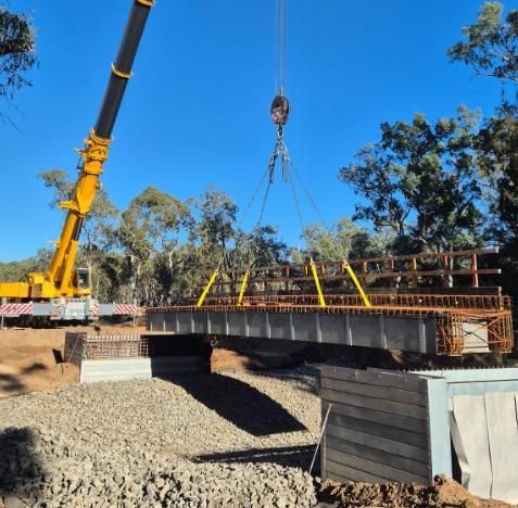 A Crane is Lifting a Bridge Over a River — Lohman Contracting in Emerald, QLD
