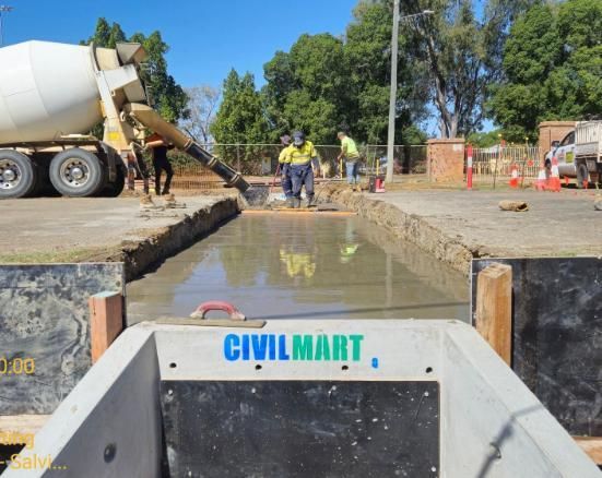 A Concrete Mixer is Pouring Concrete Into a Hole in the Ground — Lohman Contracting in Emerald, QLD