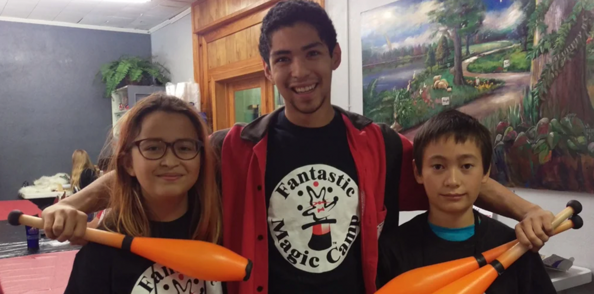 a group of young people are standing next to each other holding juggling pins .