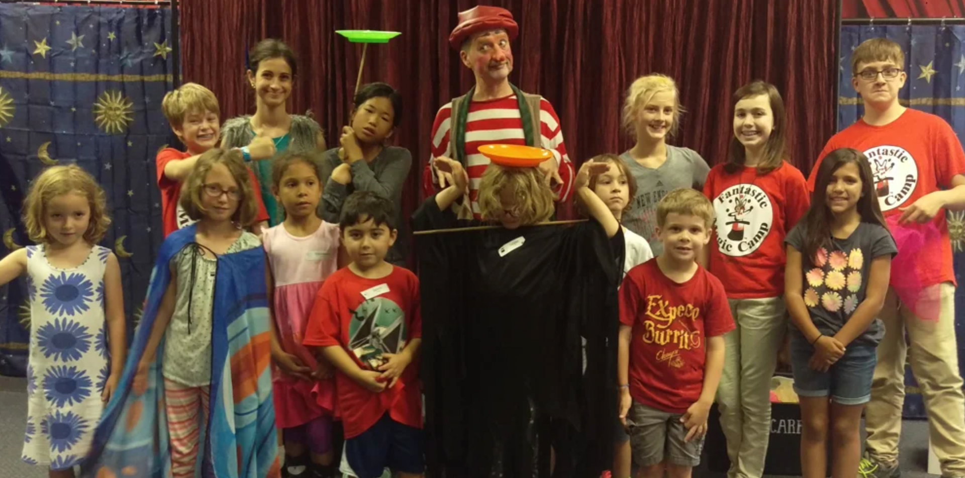 a group of children are posing for a picture with a clown .