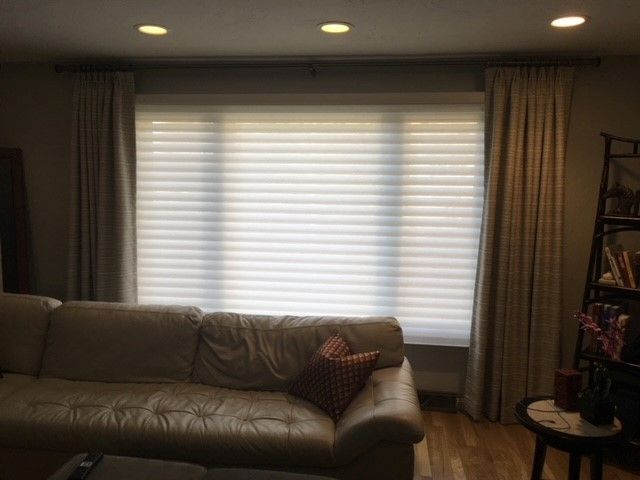 A living room with a couch and a table with a vase of flowers on it