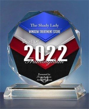 A glass trophy that says `` the shady lady window treatment store '' is sitting on a table.