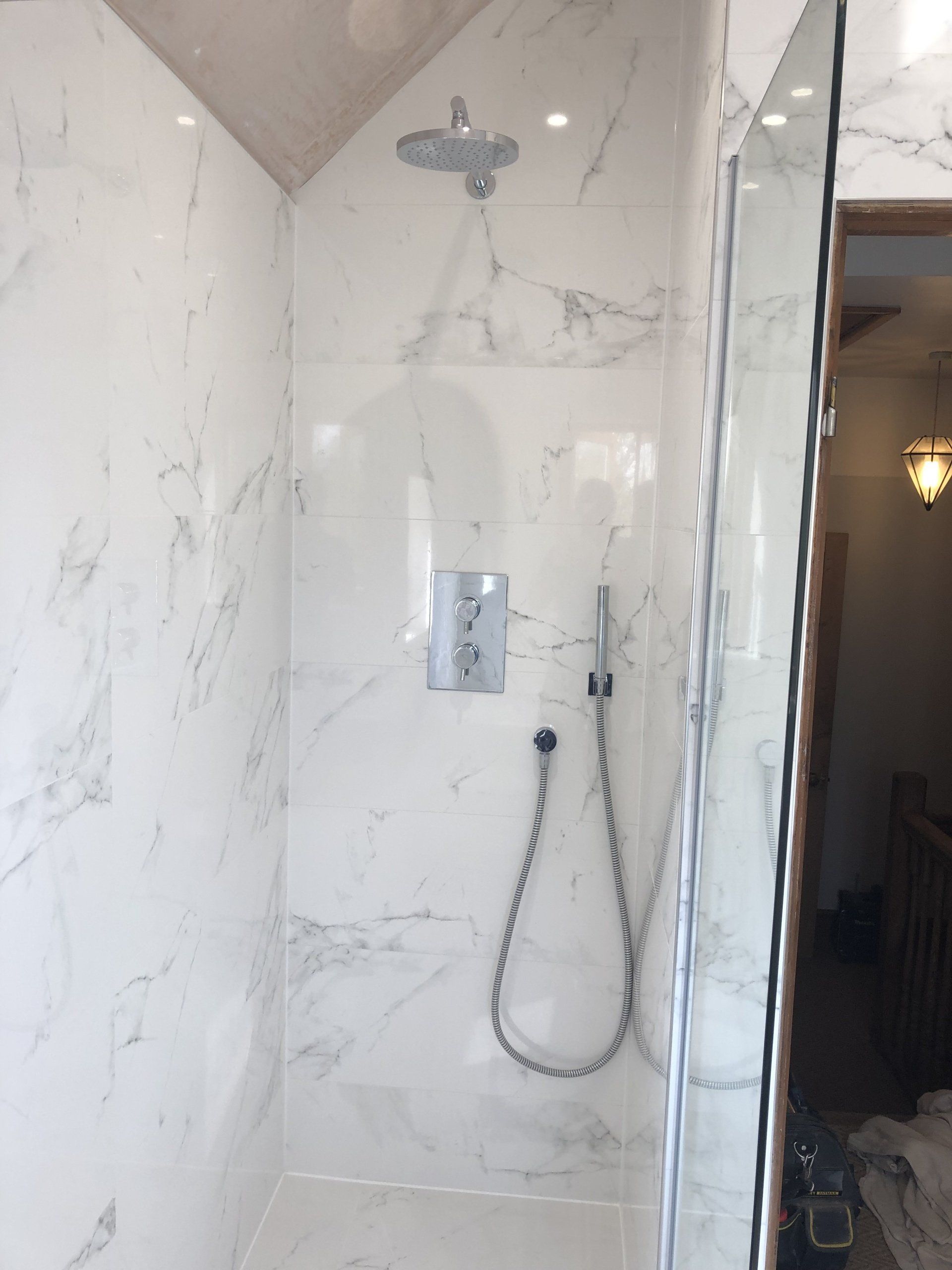 Please look below to find a complete transformation- we created a walk in shower room with beautiful white marble tiles with gloss white furniture.