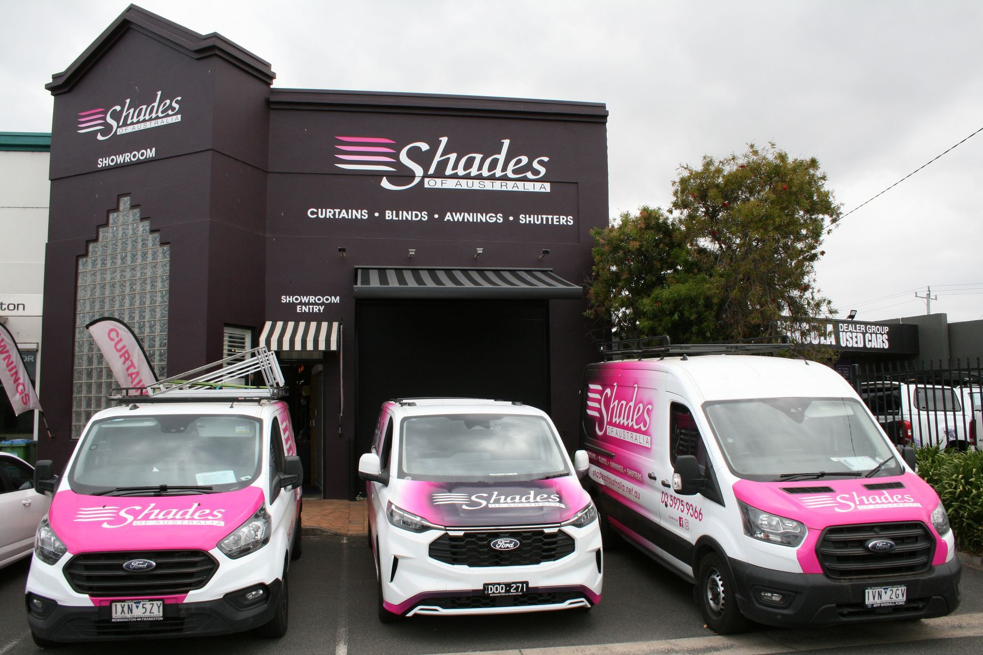 Fabric samples and curtains displayed in a store, showcasing various colors and textures.