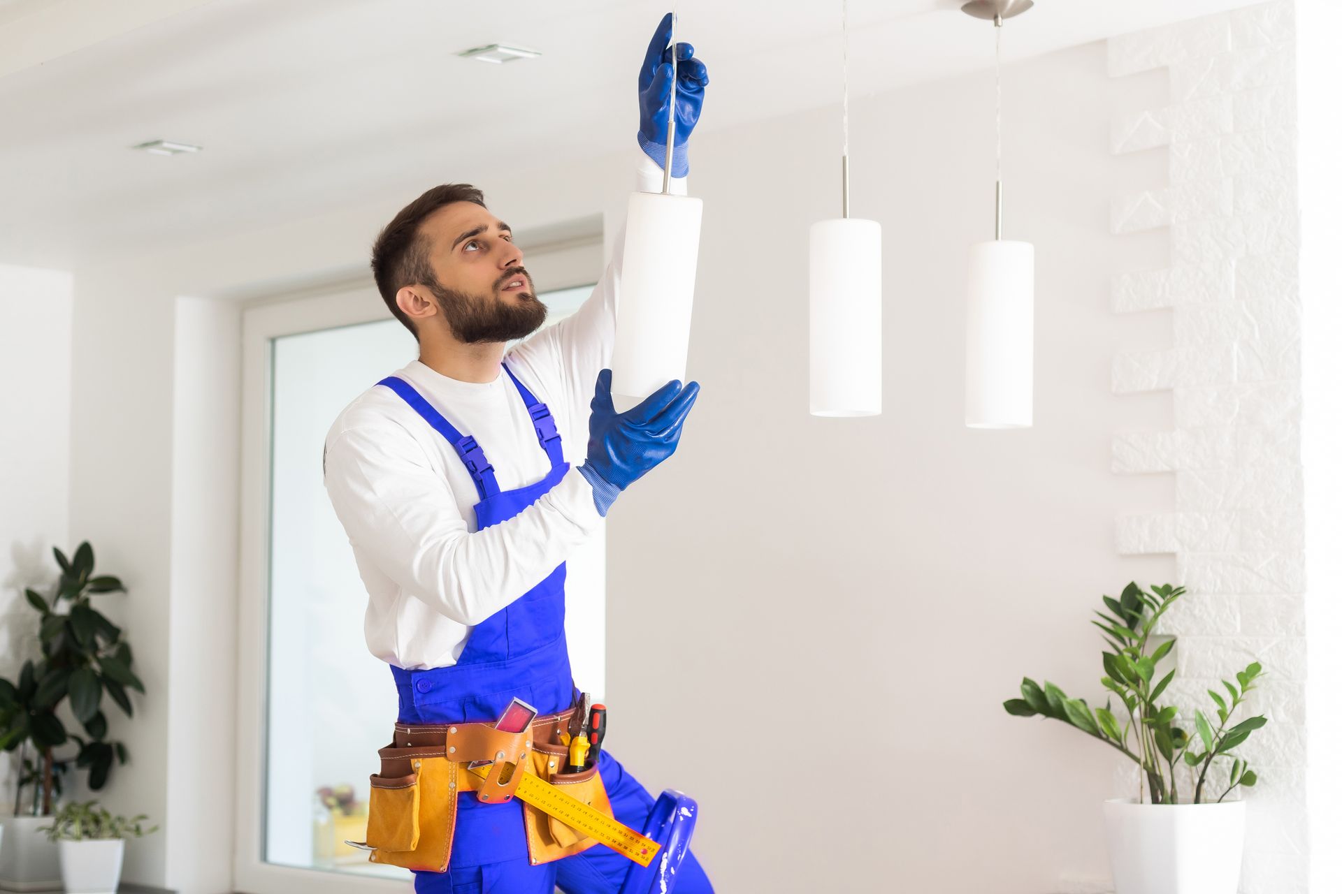 Electrician installing led light bulbs in ceiling lamp