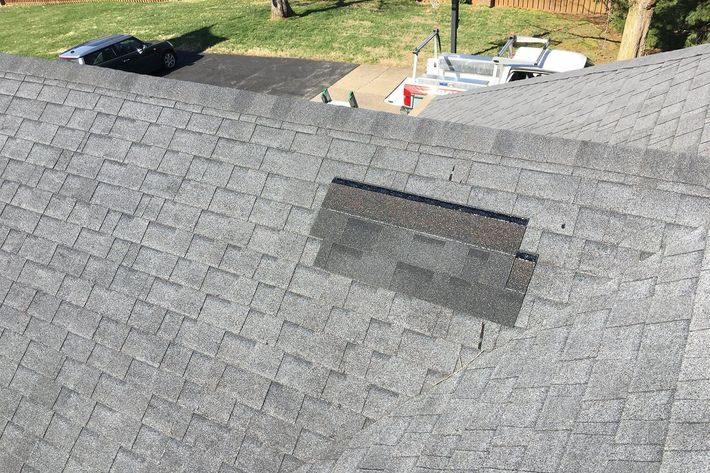 Gray shingle roof with a patched rectangular area near the ridge, viewed from above