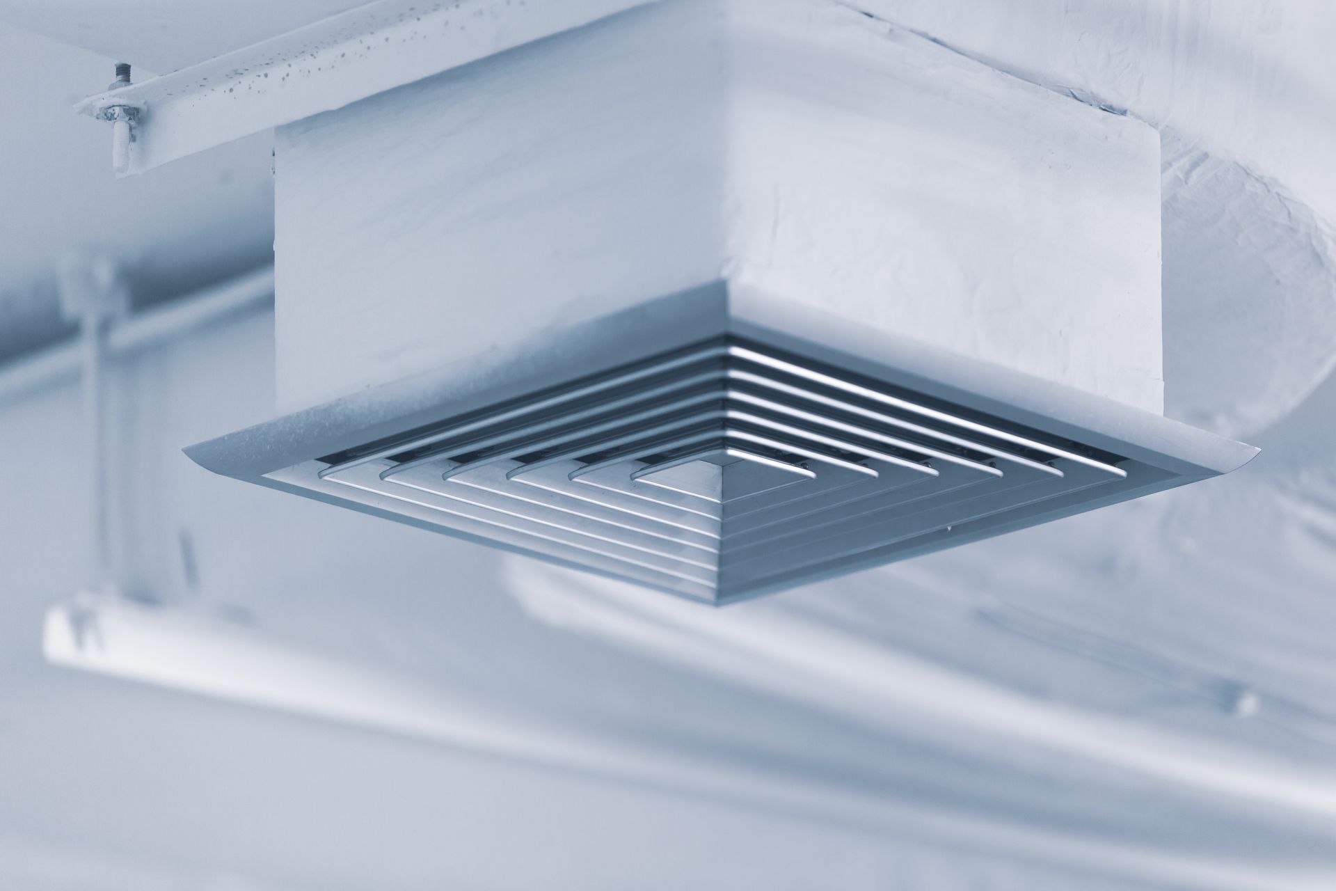 White ceiling vent grille in an industrial or office ceiling