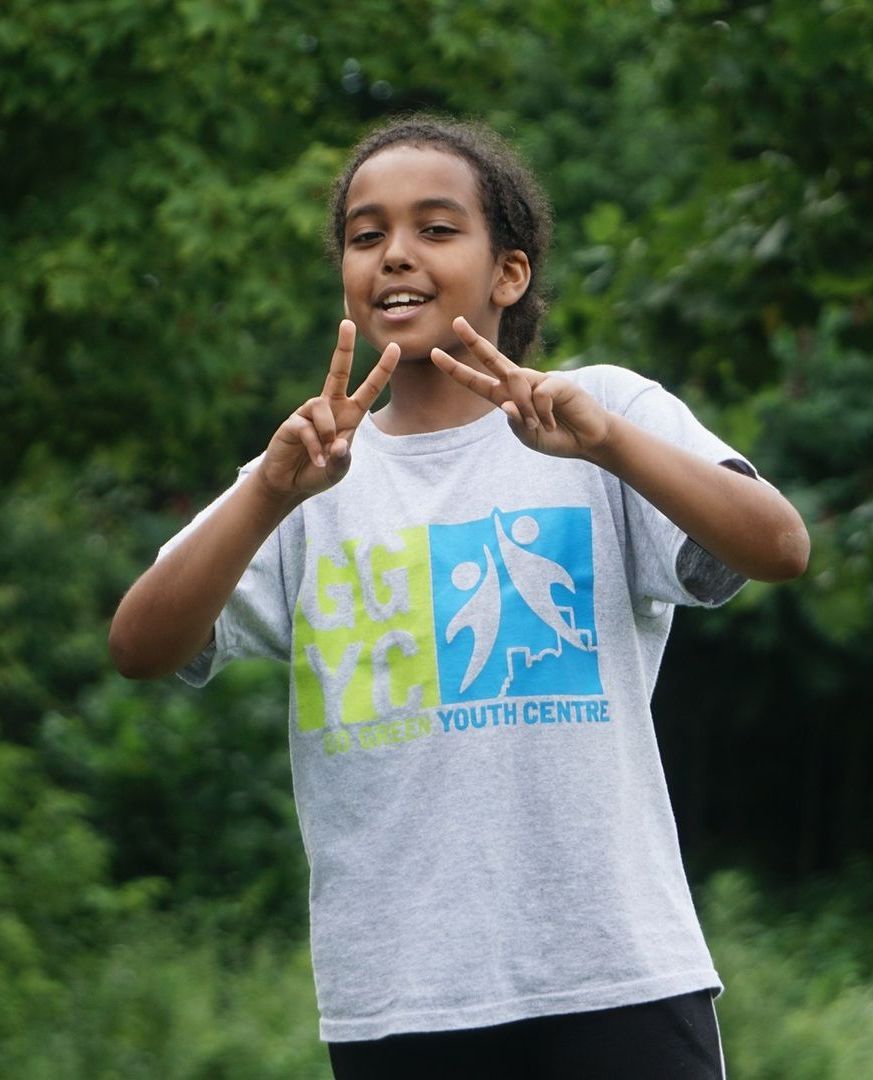A group of young men are sitting on the floor in a gym
