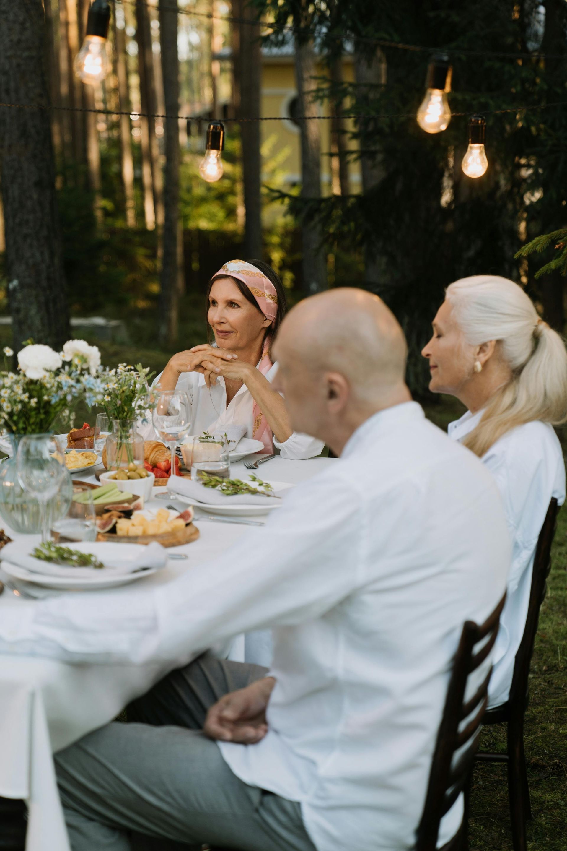 A group of people are sitting at a table with plates of food.