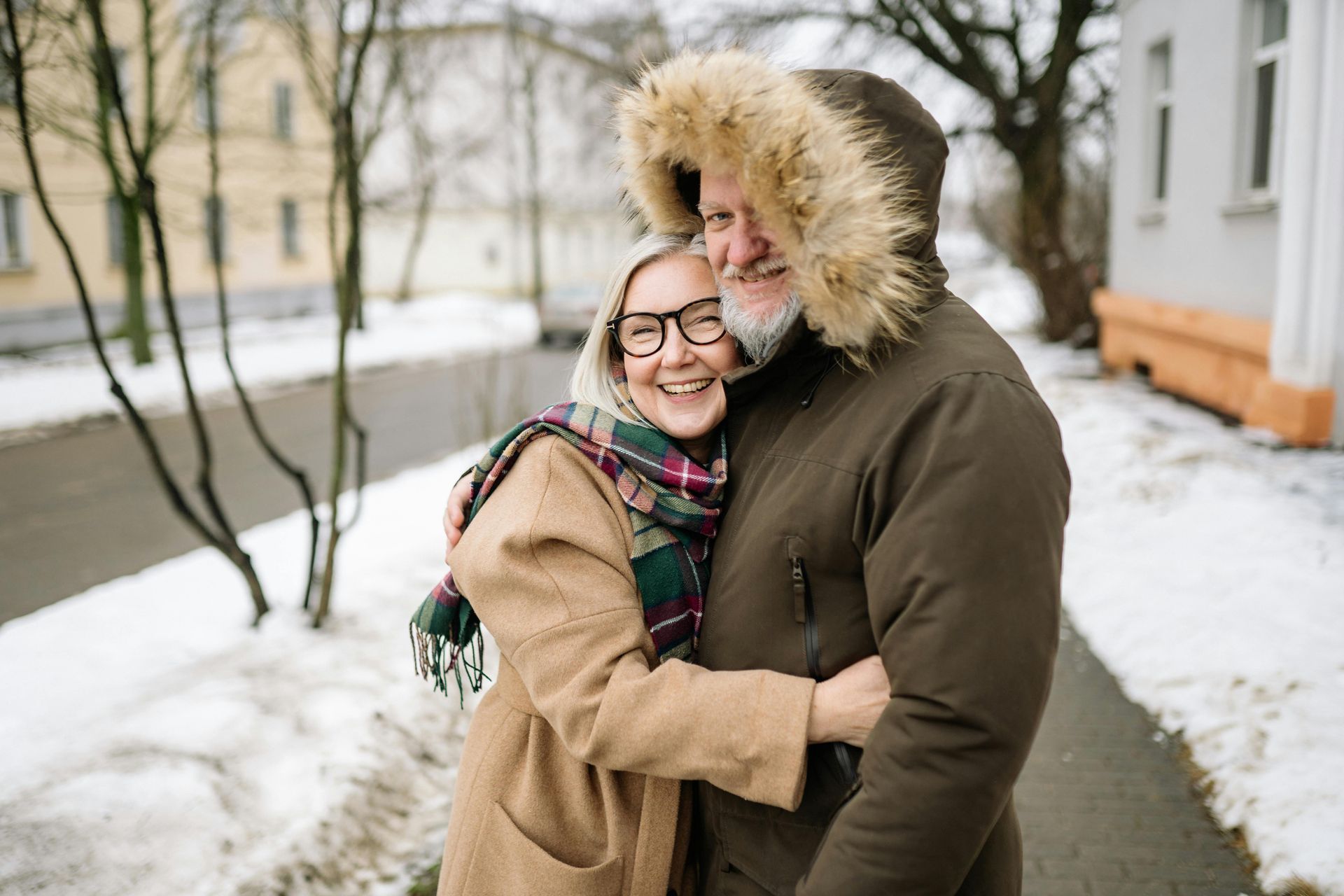 A man and a woman are hugging each other in the snow.