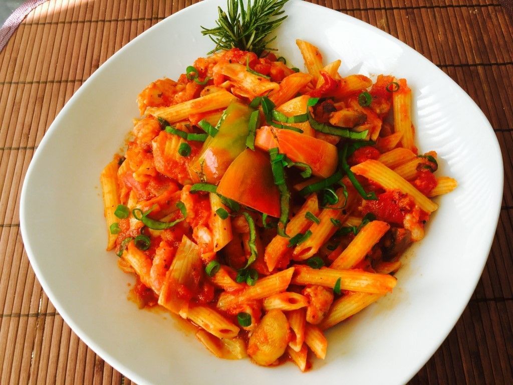 A white plate topped with pasta and vegetables on a table