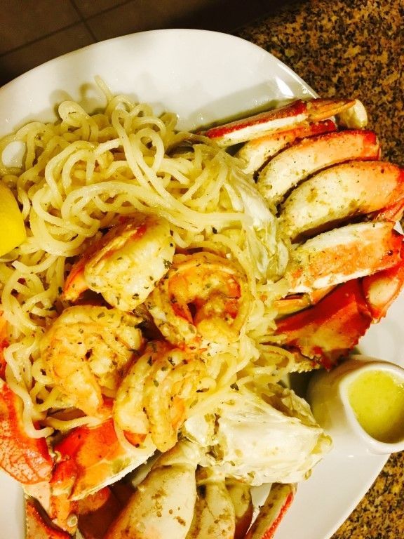 A white plate topped with noodles shrimp and crab