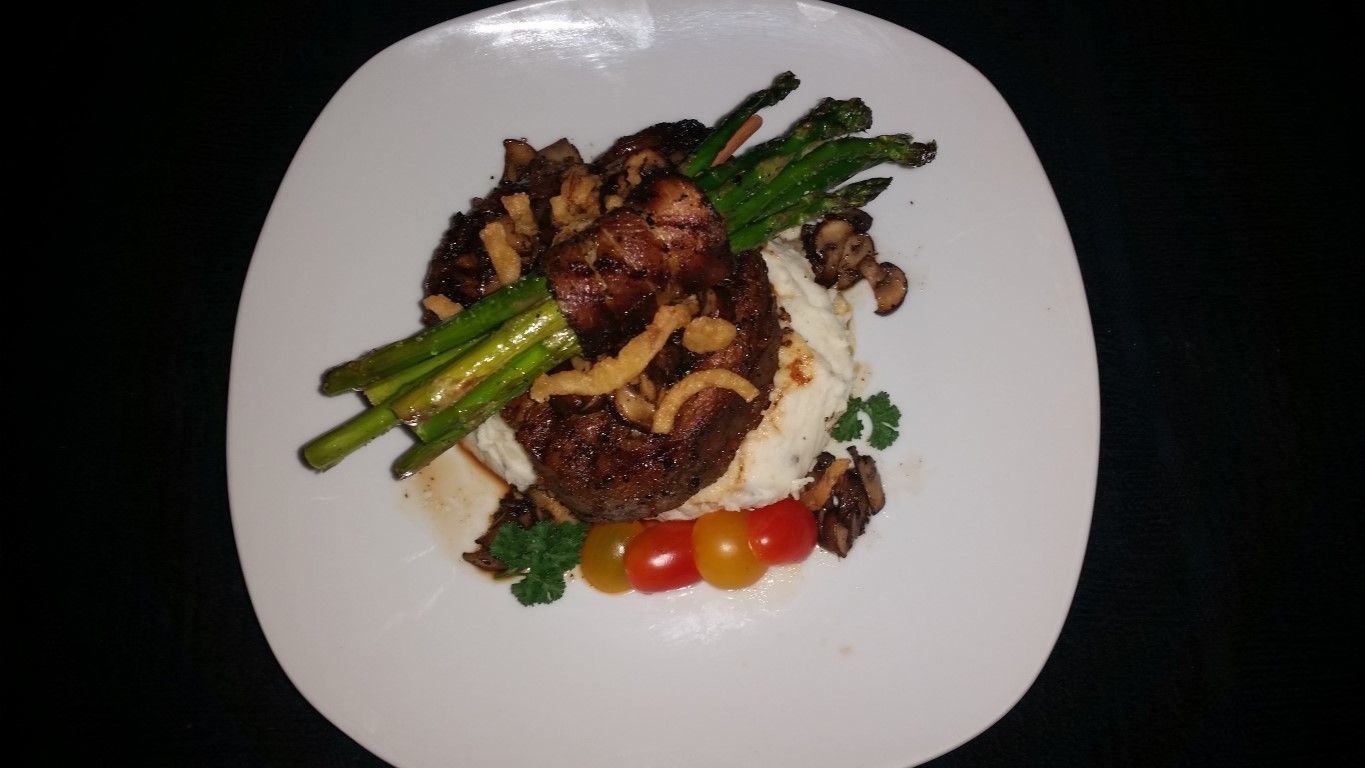 A white plate topped with meat , mashed potatoes , green beans and tomatoes.