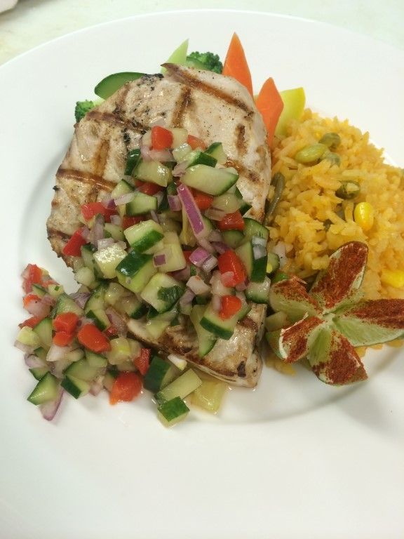 A white plate topped with grilled chicken rice and vegetables