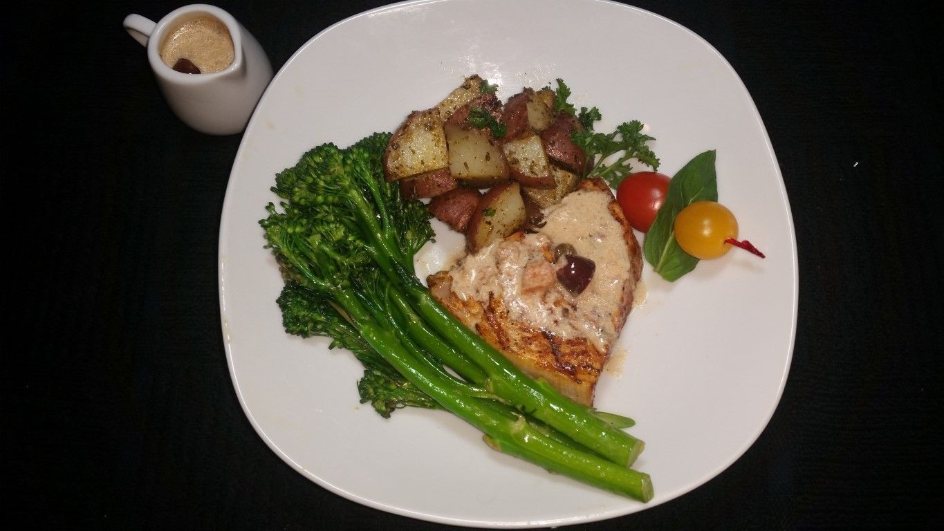 A white plate topped with meat asparagus and potatoes