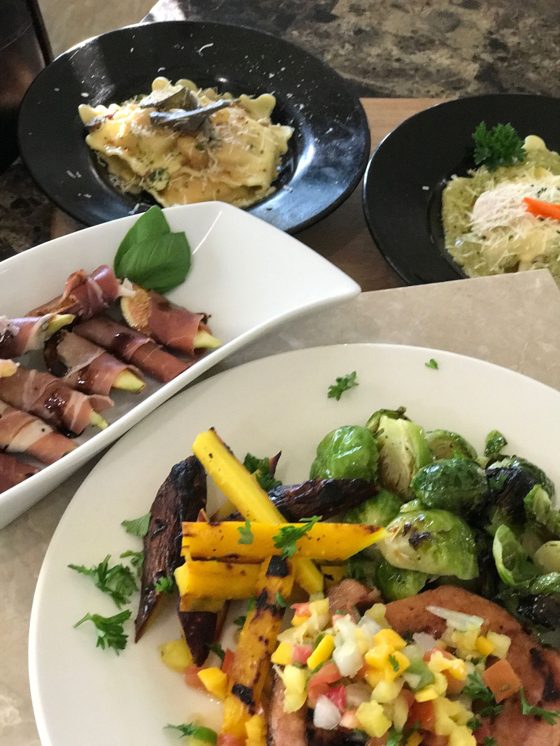 Three plates of food are on a table with a fork in one of them