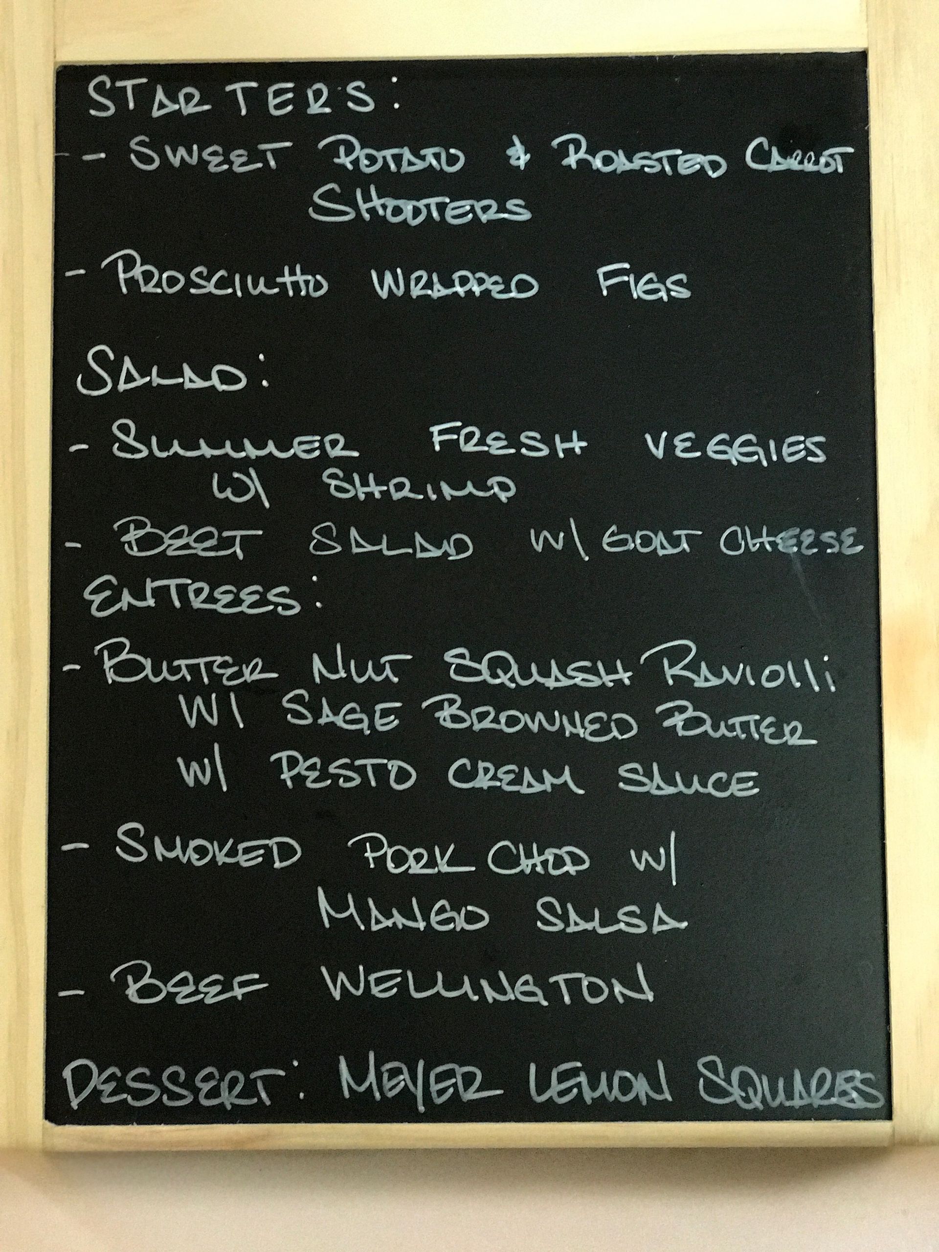 A chalkboard with a list of starters and desserts