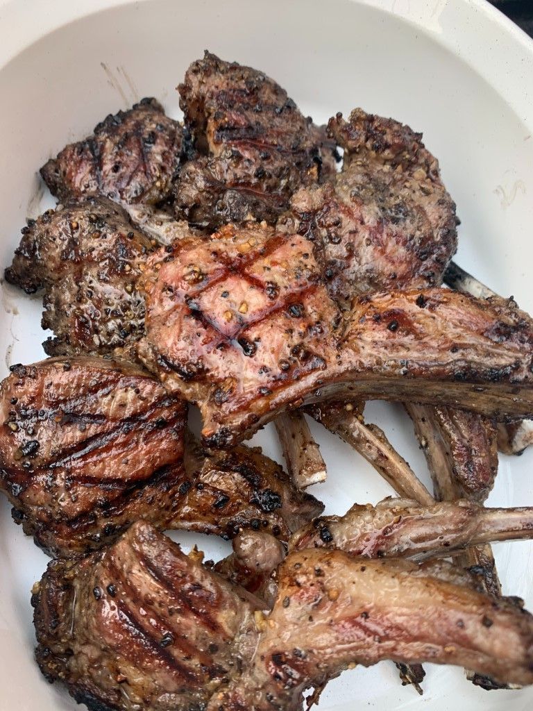 A white plate topped with grilled lamb chops.
